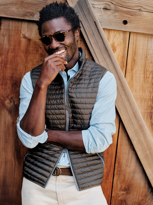 Model wearing J.McLaughlin Traveler vest in olive made with nylon.