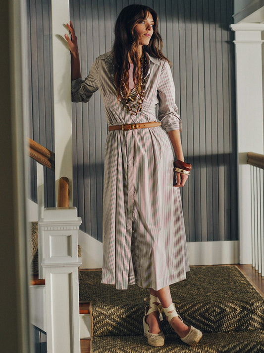 Woman wearing the Stella Dress in Stripe by J.McLaughlin, styled with a tan belt and layered necklaces, embodying effortlessly stylish, enduring designs and a legacy of timeless fashion.