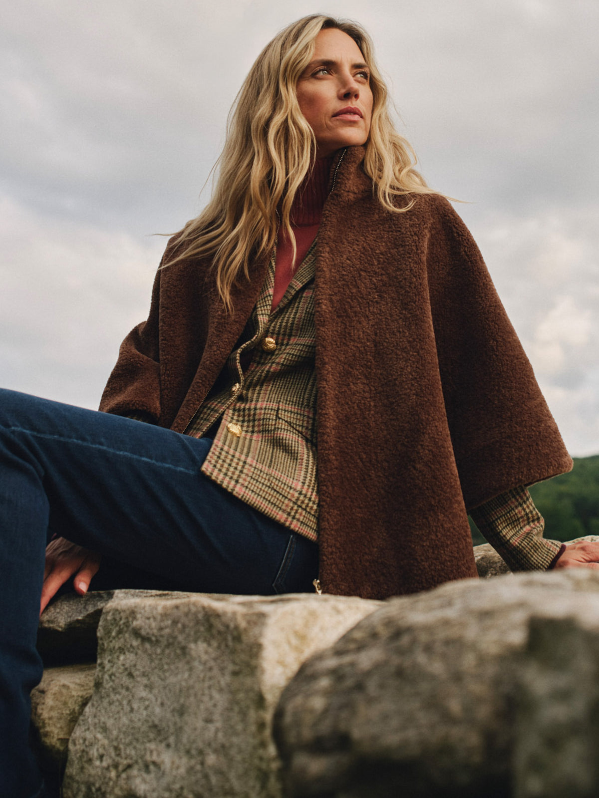 Gretchen Faux Fur Cape by J.McLaughlin styled with a plaid top and jeans as a woman enjoys a timeless outdoor look in cozy faux fur outerwear