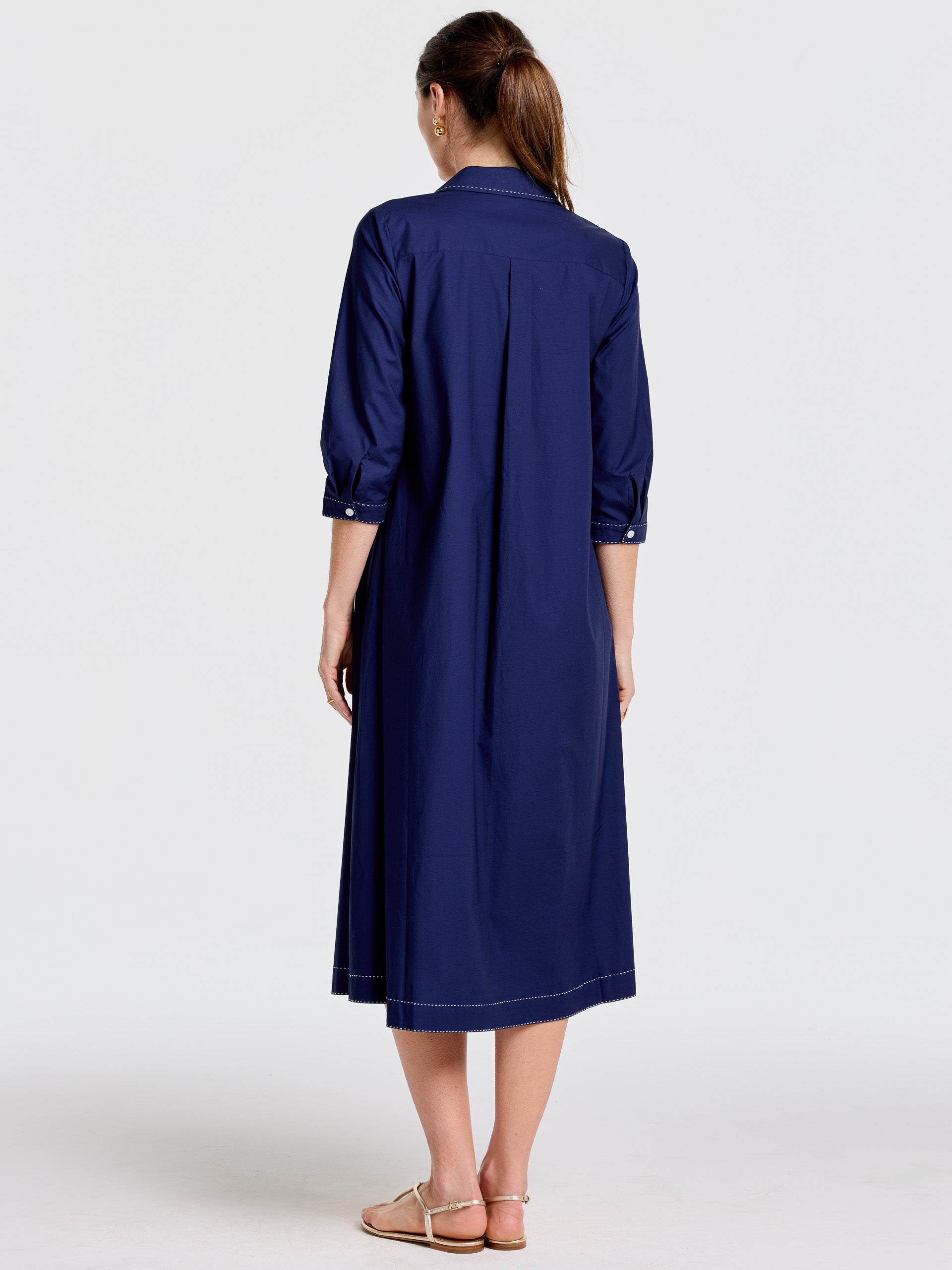 Back view of a woman wearing the Stephanie Dress by J.McLaughlin in a deep navy color, featuring three-quarter sleeves and a relaxed fit, showcasing effortlessly stylish, enduring designs with innovative fabrics. A destination for defining style. Life, Well-Lived.