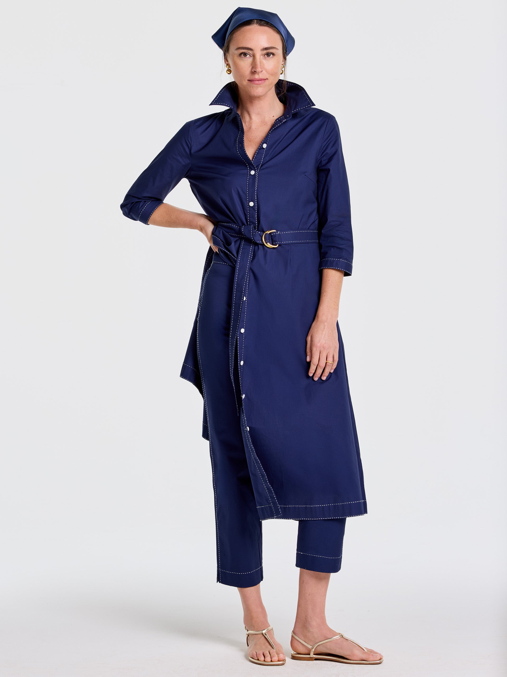 Woman wearing a navy Stephanie Dress by J.McLaughlin, featuring a belted waist, button-down front, and three-quarter sleeves. Effortlessly stylish and enduring designs embody innovative fabrics for a legacy of timeless fashion. A destination for defining style. Life, Well-Lived.