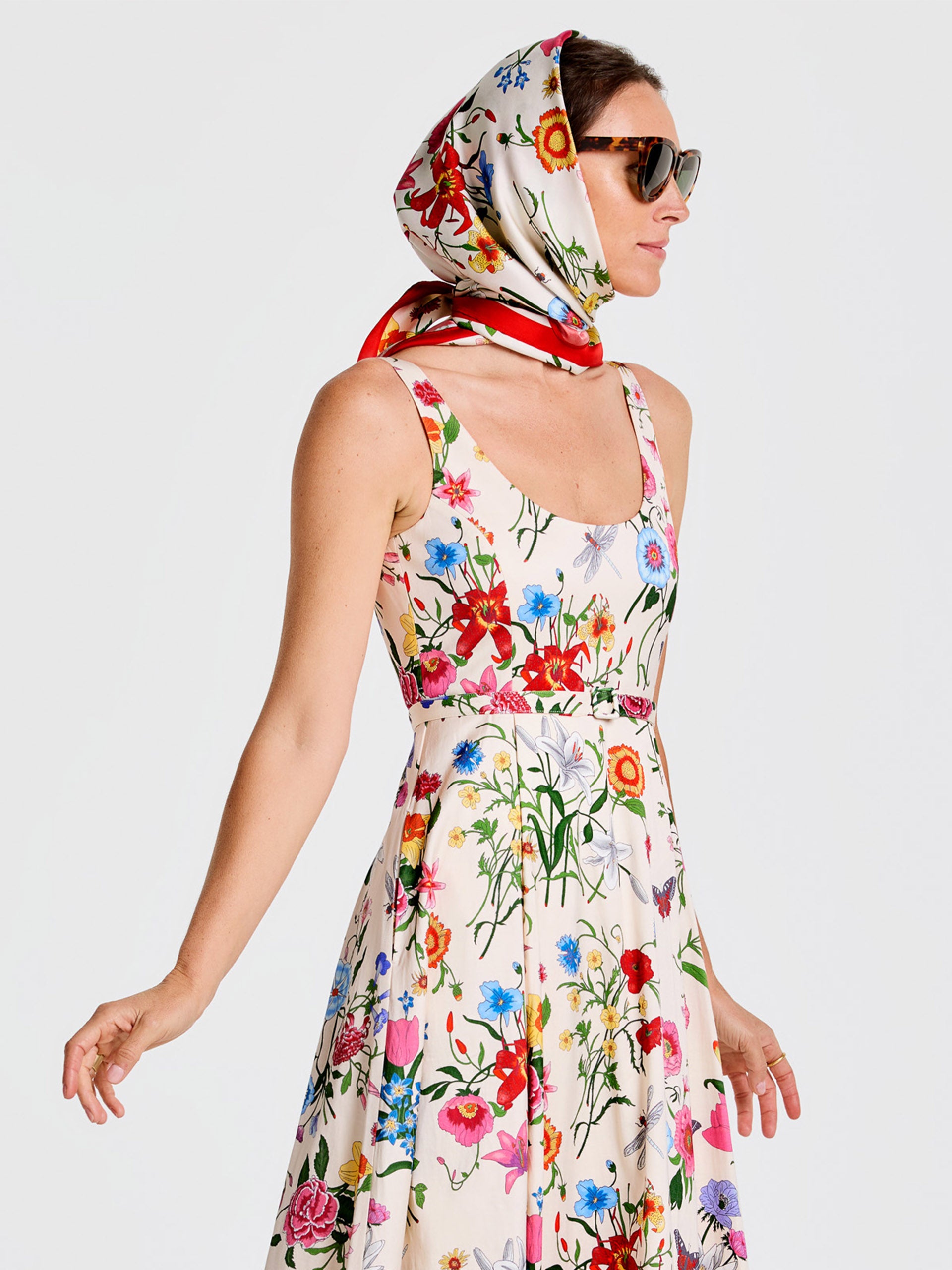 Woman wearing a floral dress and the Kyleigh Silk Scarf in Dragonfly Garden by J.McLaughlin, showcasing effortlessly stylish, enduring designs crafted with innovative fabrics.