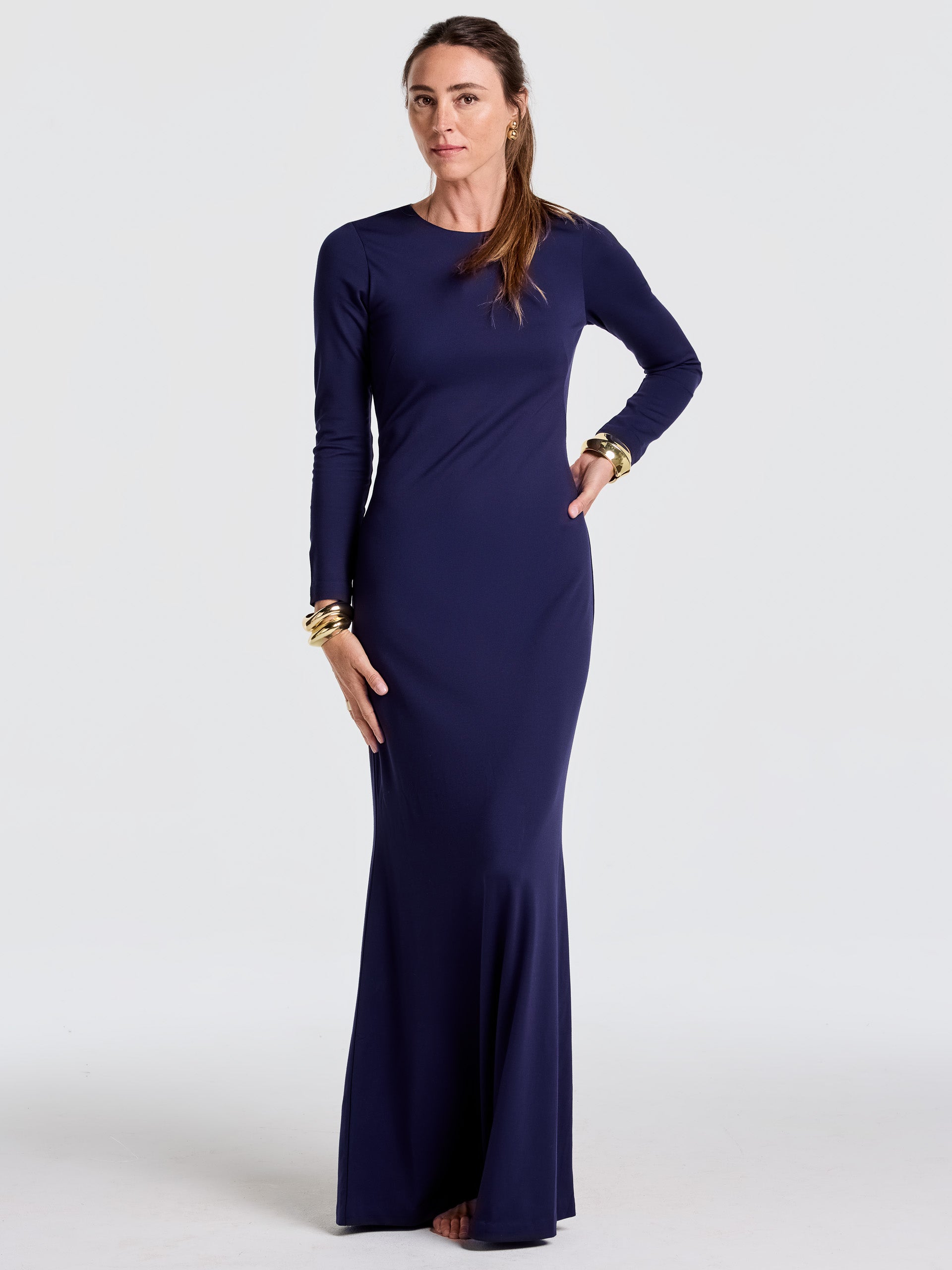 Woman wearing a sleek, navy blue Alexandra Dress by J.McLaughlin, featuring long sleeves and a fitted silhouette, showcasing effortlessly stylish, enduring designs and innovative fabrics.