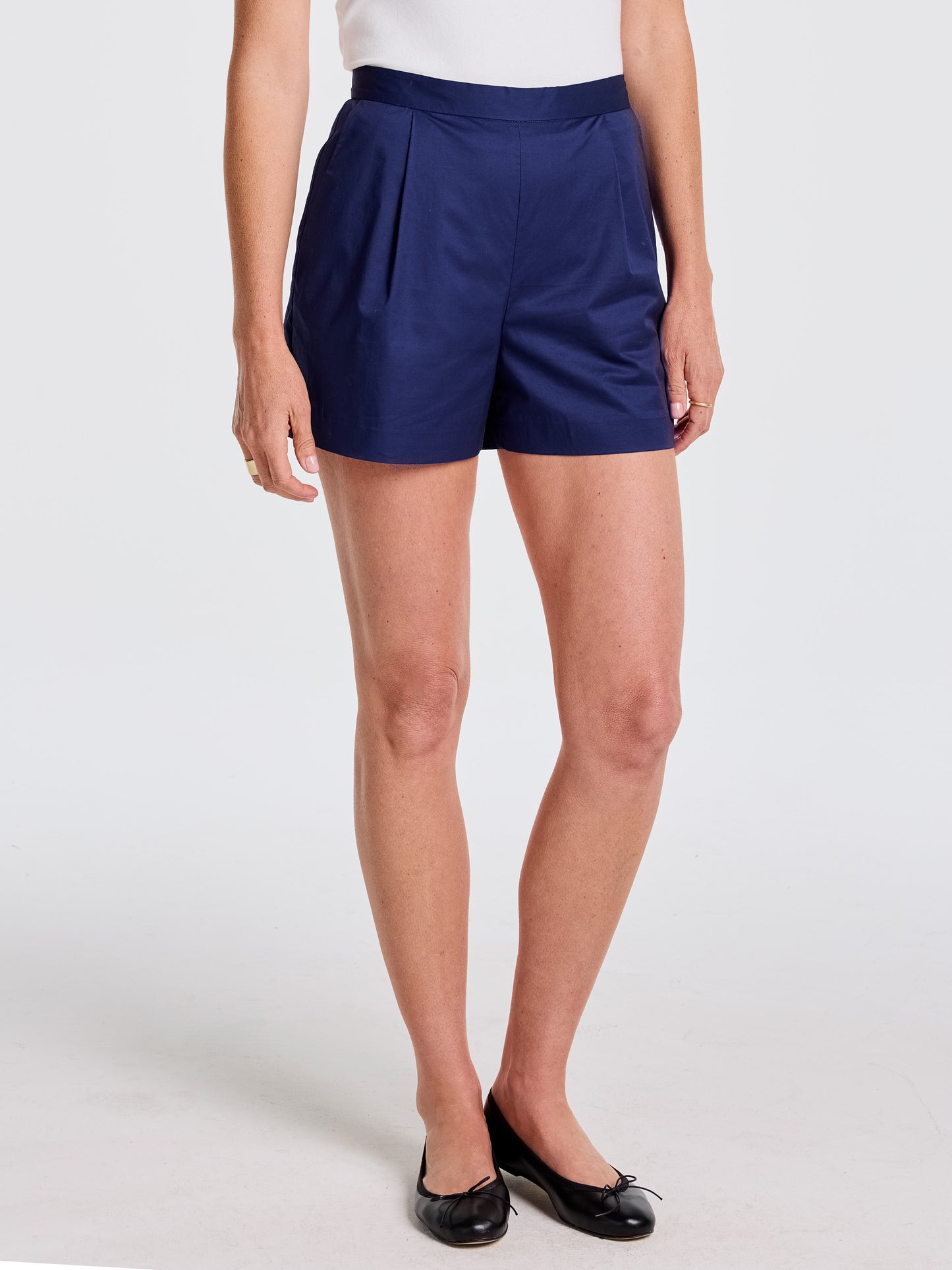Woman wearing navy blue Emily Shorts by J.McLaughlin paired with black ballet flats, showcasing effortlessly stylish shorts that reflect enduring designs and a legacy of timeless fashion. A destination for defining style. Life, Well-Lived.