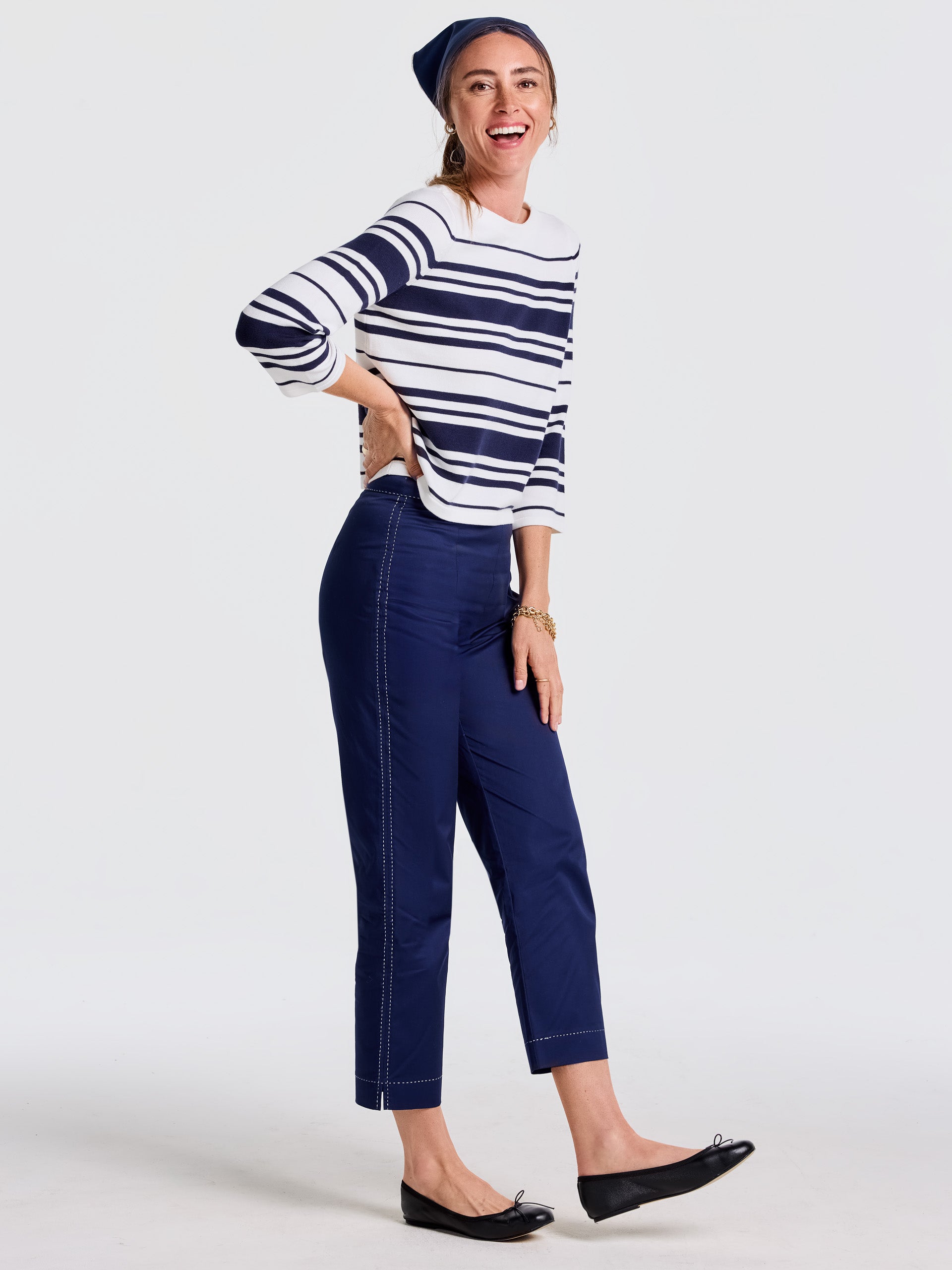 Woman wearing navy Betina Pants and a white and navy striped sweater, styled with a matching headband and black flats, reflecting J.McLaughlin’s effortlessly stylish, enduring designs and legacy of timeless fashion.
