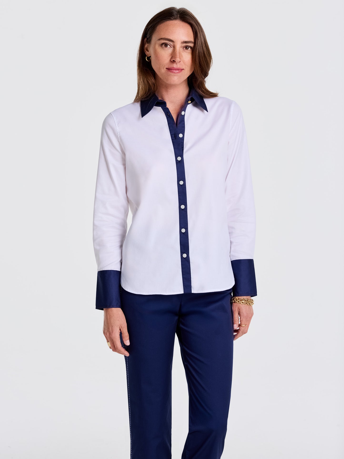 Woman wearing a Karla Shirt from J.McLaughlin featuring a classic white design with navy collar, cuffs, and button placket paired with navy pants, showcasing effortlessly stylish, enduring designs with innovative fabrics. A destination for defining style. Life, Well-Lived.