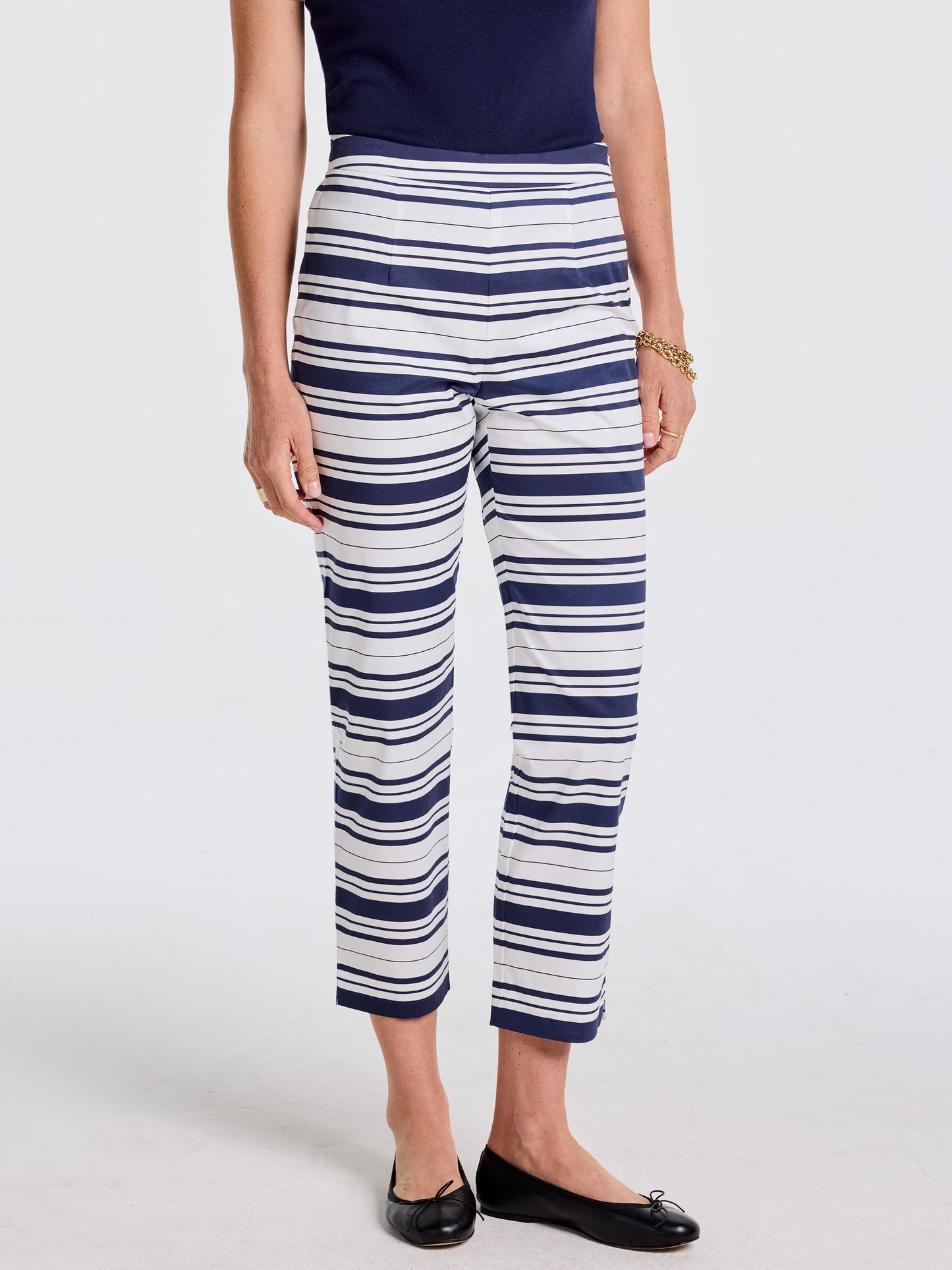Woman wearing Betina Pants in Mariner Stripe by J. McLaughlin paired with a navy top and black flats, showcasing effortlessly stylish, enduring designs and a legacy of timeless fashion.