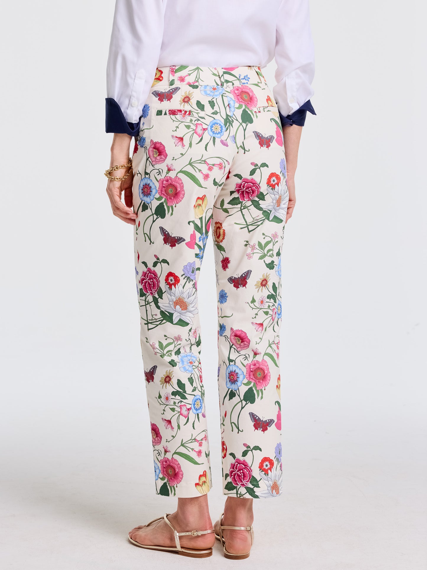 Woman wearing Avery Pants in Dragonfly Garden by J.McLaughlin, featuring vibrant floral and butterfly patterns in a comfortable, effortlessly stylish fit, embodying enduring designs and innovative fabrics for a destination defining style. Life, Well-Lived.