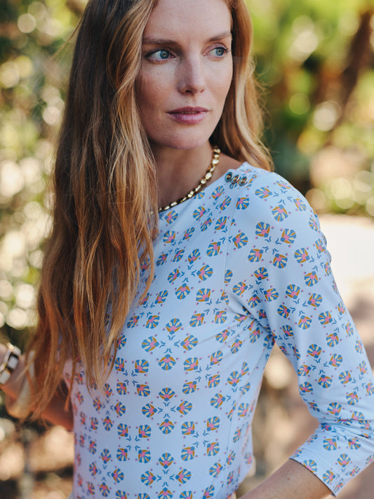 Woman wearing a J.McLaughlin Wavesong Tee in Mythic Tile with a subtle geometric pattern, paired with a gold necklace, showcasing effortlessly stylish and enduring designs.
