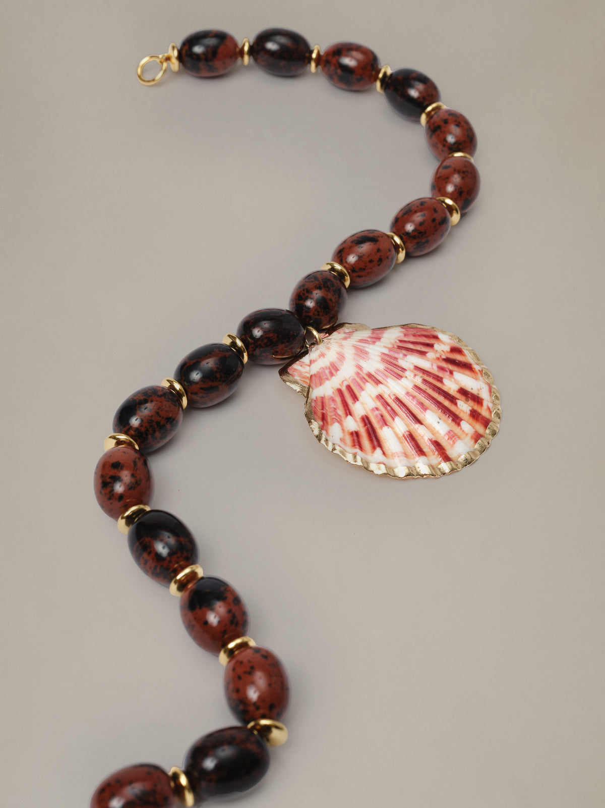 J.McLaughlin Shell Necklace with dark marbled beads and a natural shell pendant for playful getaway style on a neutral background