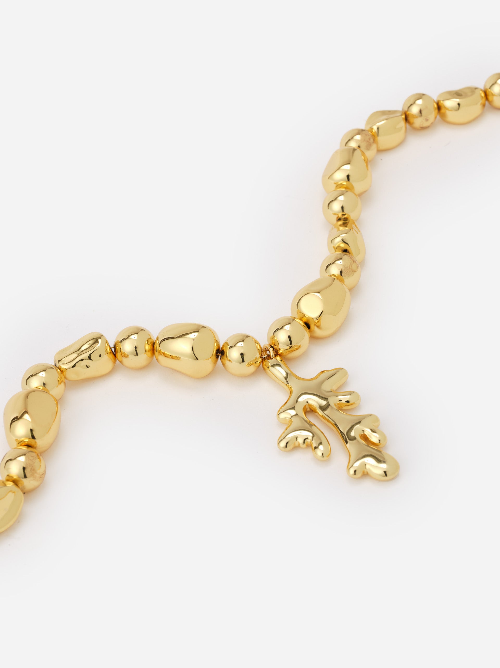 Close-up of a gold-tone Coral Necklace by J.McLaughlin featuring polished, irregularly shaped beads and a coral-inspired pendant, embodying effortlessly stylish, enduring design.