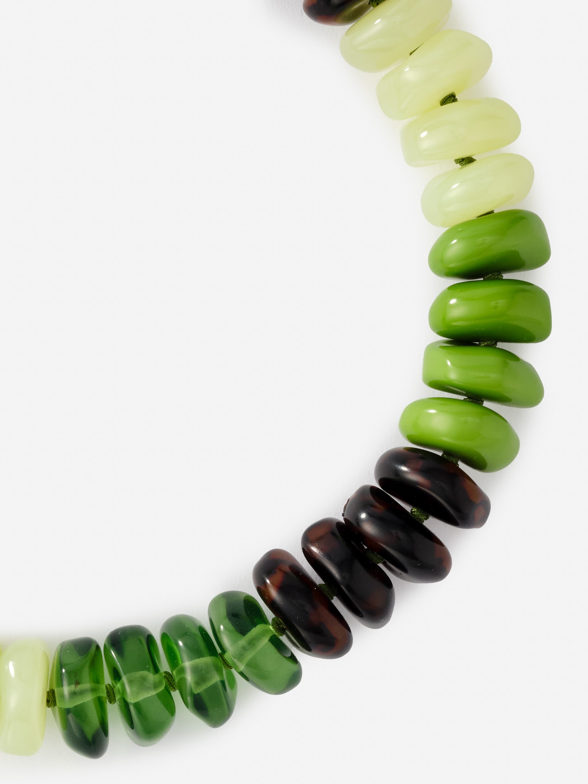 Close-up of a Tonal Bead Necklace by J.McLaughlin featuring glossy beads in shades of green, amber, and cream, showcasing effortlessly stylish and enduring designs.