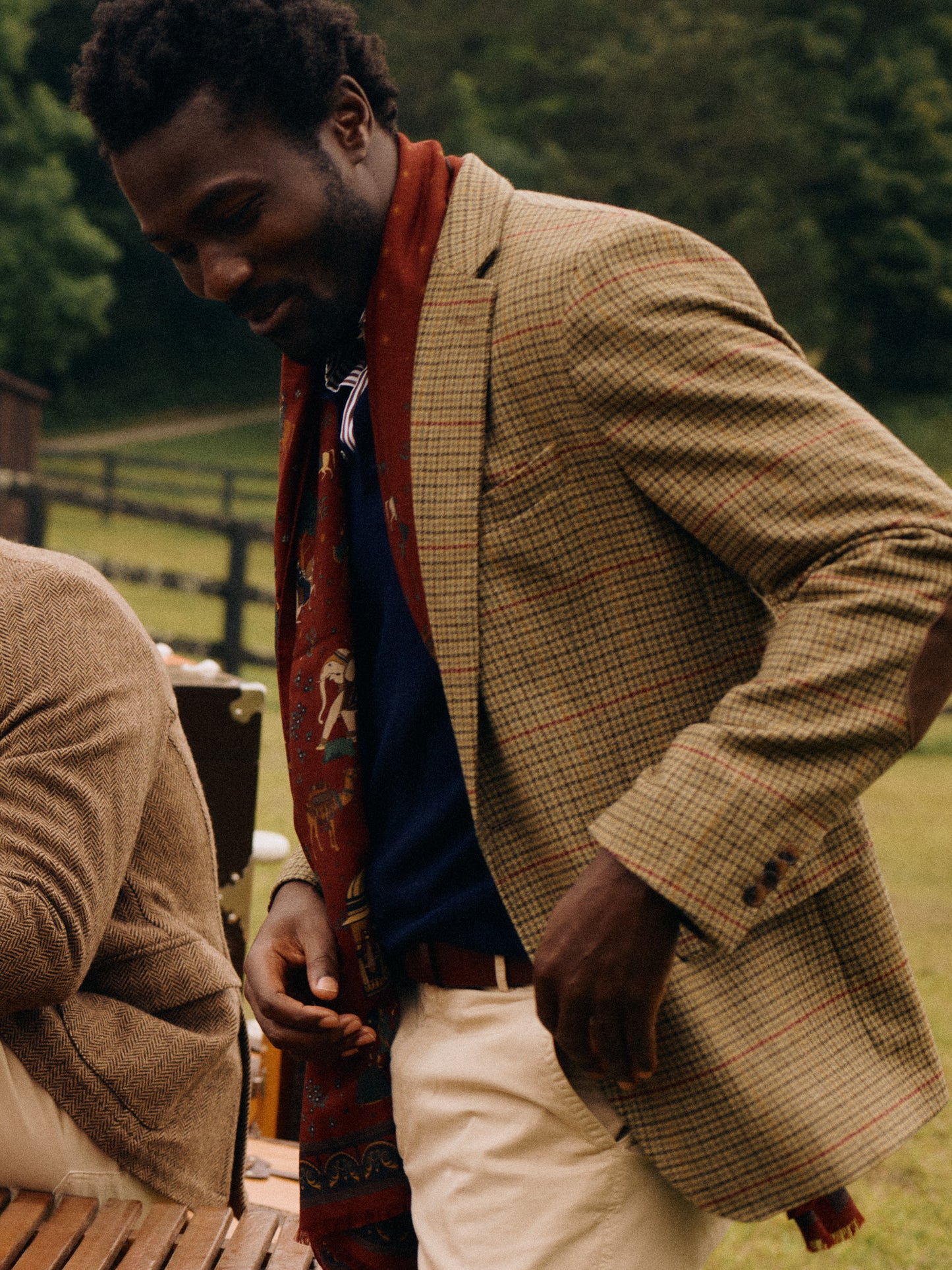 Model wearing J.McLaughlin Suffolk blazer in brown/green/red/mustard made with wool.