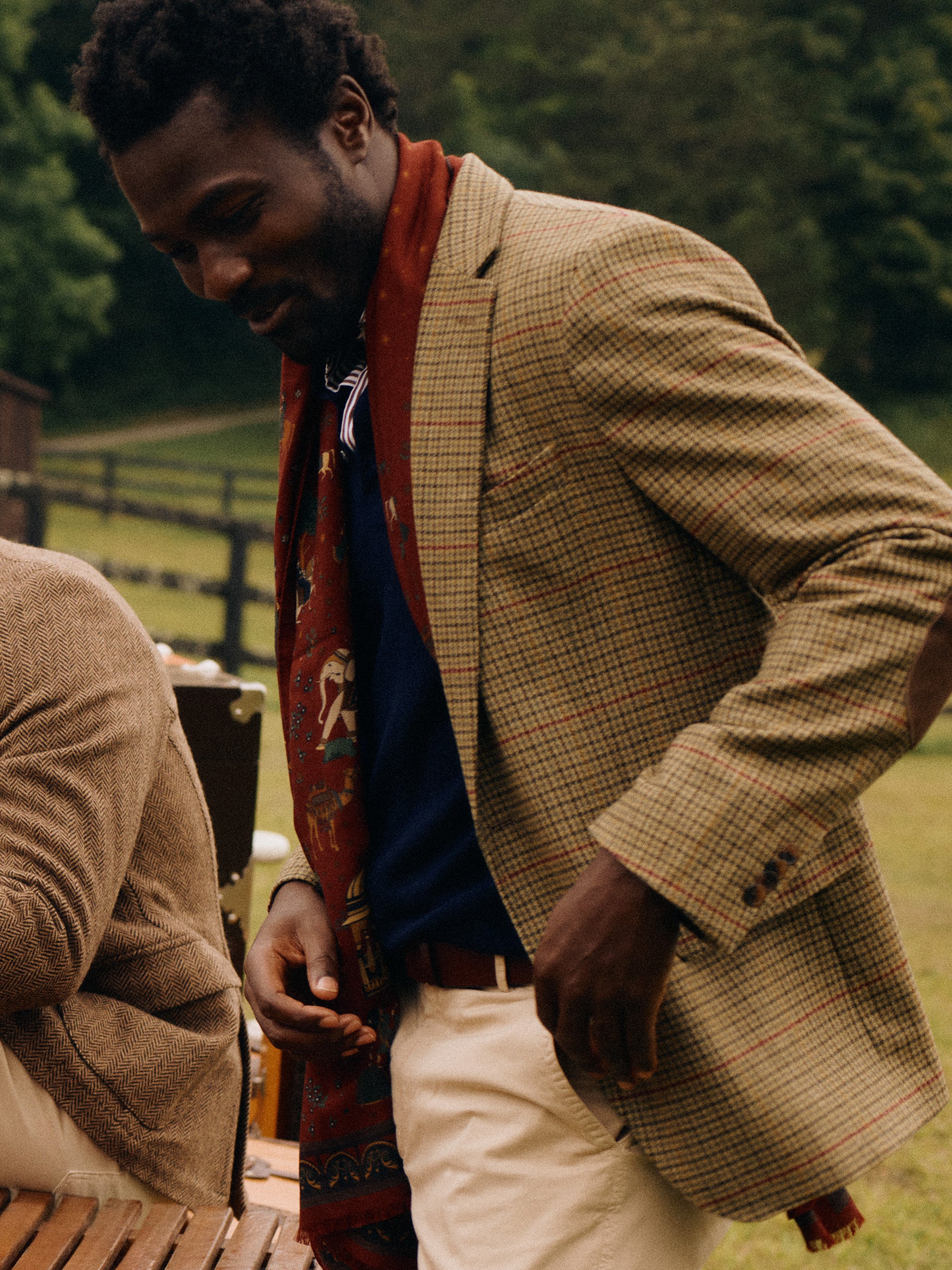 Model wearing J.McLaughlin Suffolk blazer in brown/green/red/mustard made with wool.