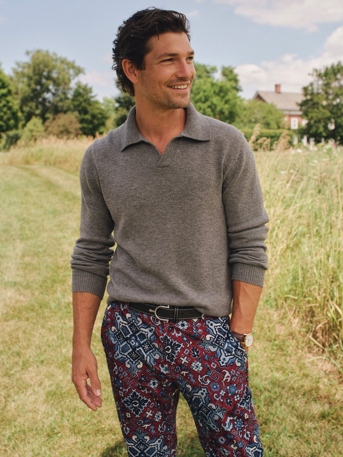 J.McLaughlin Philip Sweater in a wool and cashmere blend with an open neckline worn with patterned trousers in a sunlit meadow