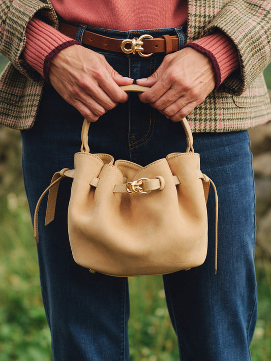 The Mini Lex Suede Handbag by J.McLaughlin in tan suede with top handles and a crossbody strap styled with jeans and a plaid jacket