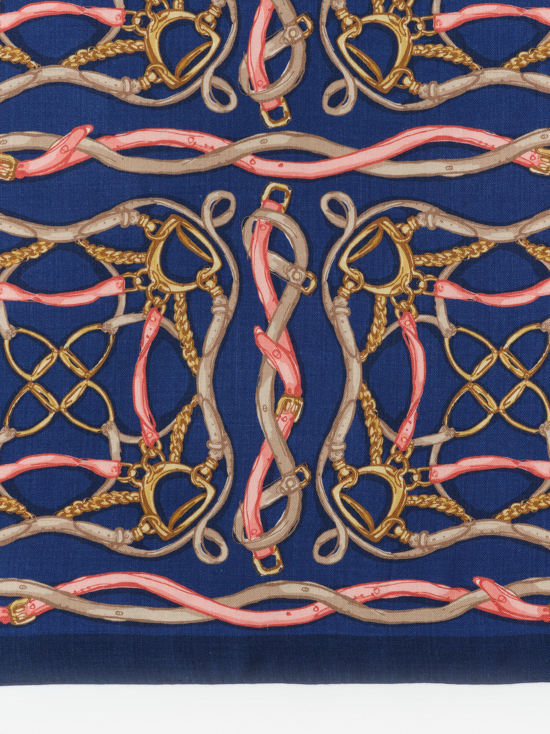 Intricately patterned Sarita Scarf in Riding Lessons Corner by J.McLaughlin, featuring intertwined belts and chains on a deep blue background, showcasing enduring designs and timeless style.