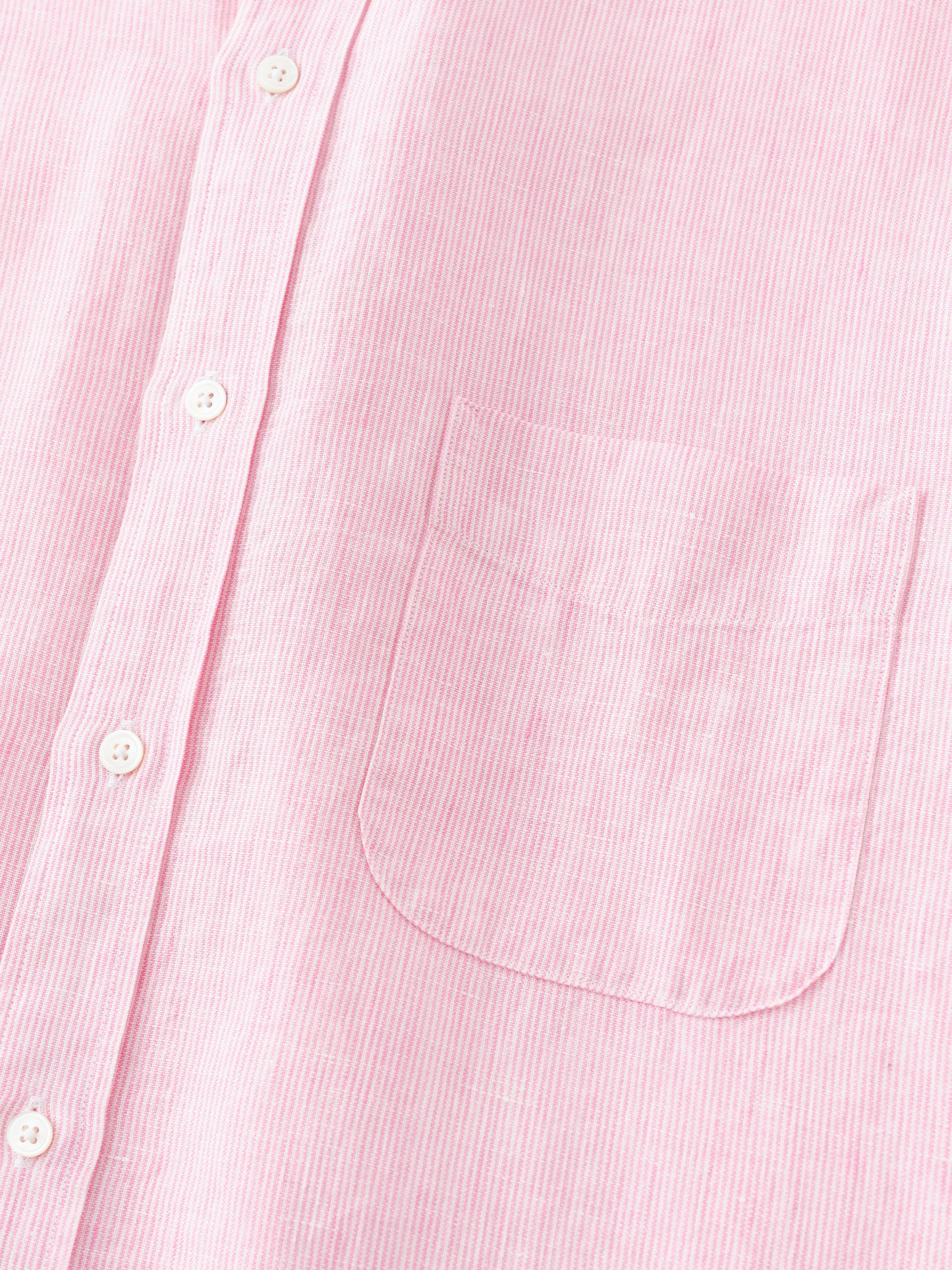 Close-up of the Gramercy Linen Shirt in Hairline Stripe by J.McLaughlin, featuring a soft pink and white striped pattern with white buttons and a chest pocket, embodying effortlessly stylish, enduring designs crafted from innovative fabrics in a legacy of timeless fashion. A destination for defining style. Life, Well-Lived.