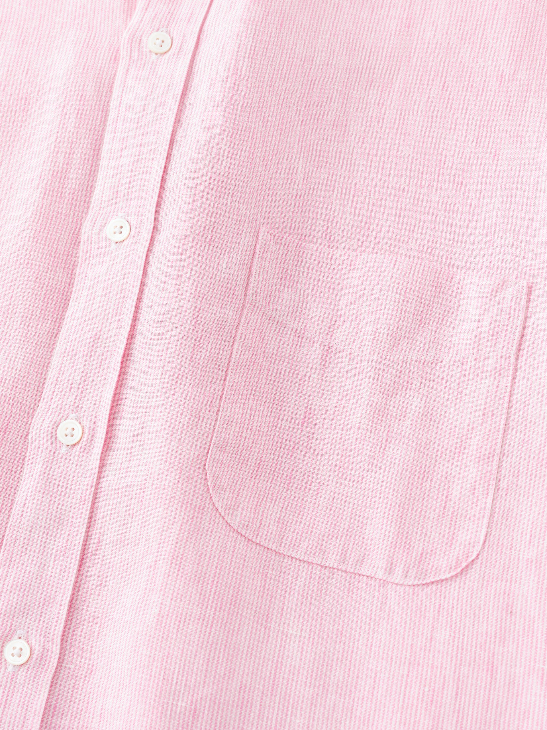 Close-up of the Gramercy Linen Shirt in Hairline Stripe by J.McLaughlin, featuring a soft pink and white striped pattern with white buttons and a chest pocket, embodying effortlessly stylish, enduring designs crafted from innovative fabrics in a legacy of timeless fashion. A destination for defining style. Life, Well-Lived.