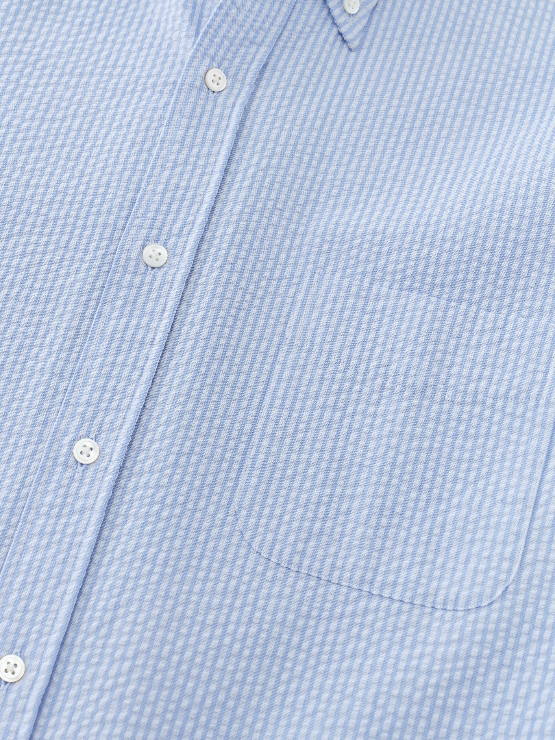 Close-up of Belvedere Cotton Seersucker Shirt in Stripe by J.McLaughlin, showcasing its lightweight striped fabric and button details that reflect effortlessly stylish, enduring designs and innovative fabrics.