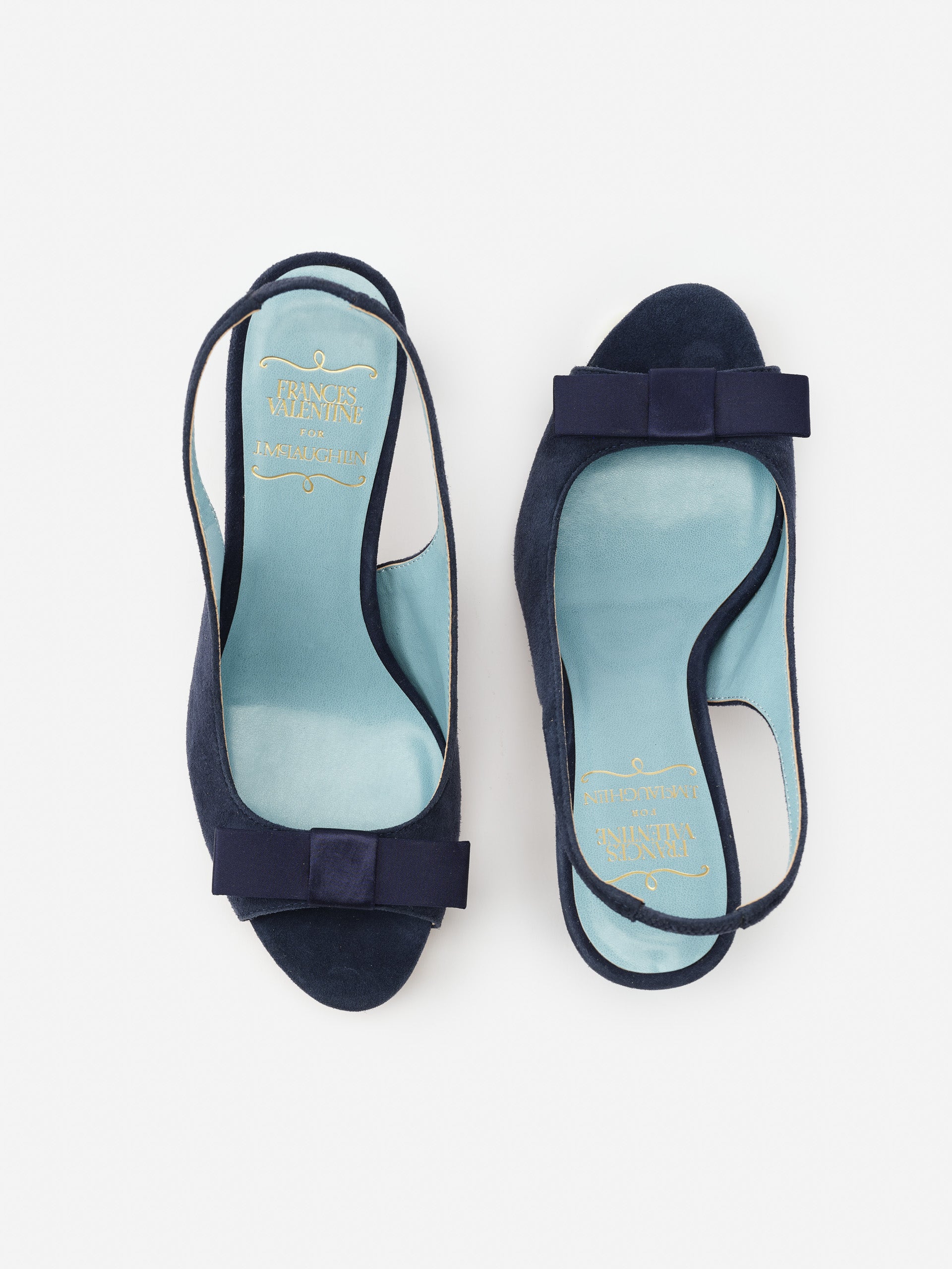 Reese Suede Slingbacks in navy by J.McLaughlin feature effortlessly stylish suede material with a chic bow detail, embodying enduring designs and a legacy of timeless fashion.