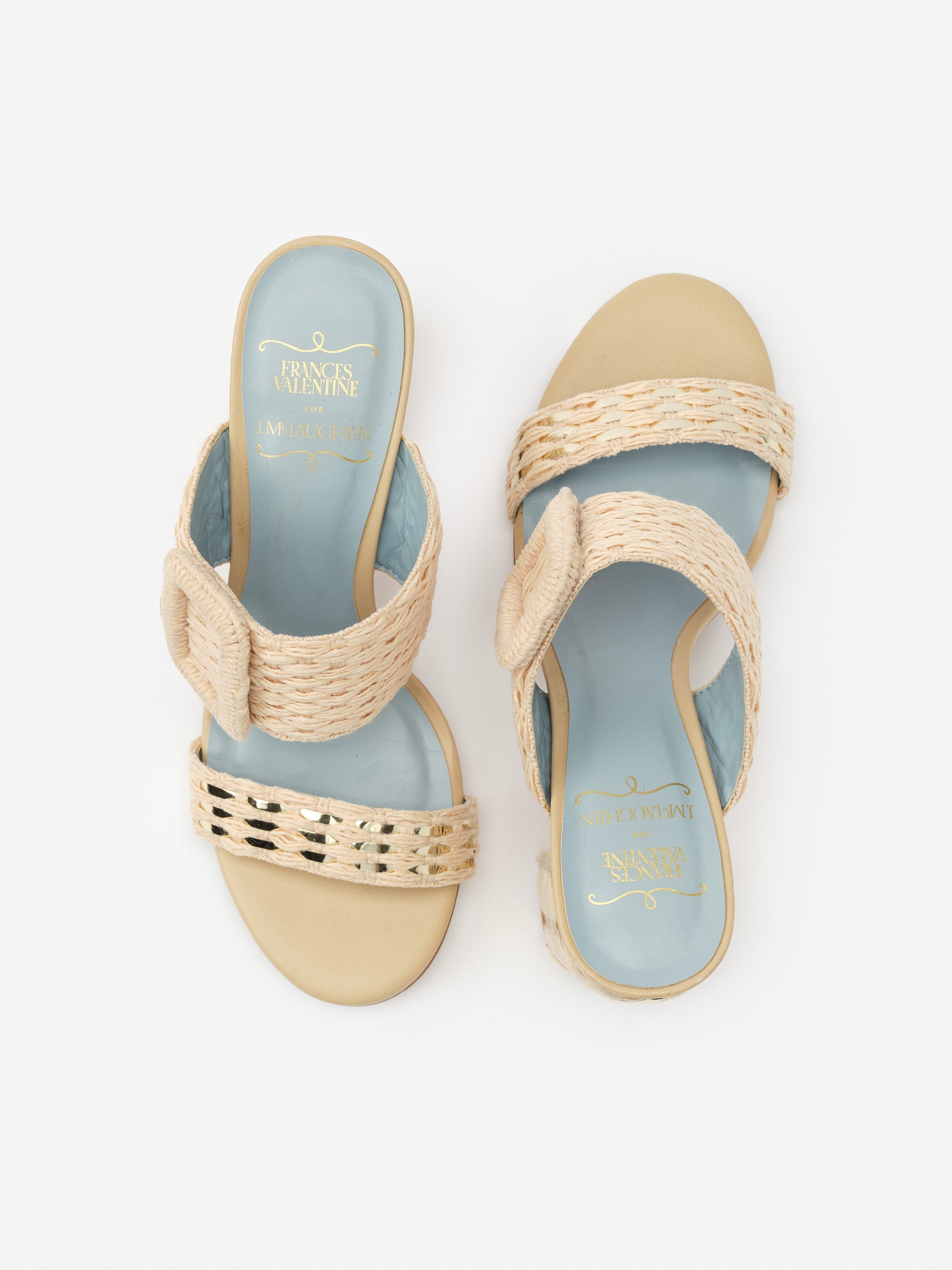 A pair of Betty Heels by J.McLaughlin featuring woven beige straps with a light blue footbed, combining effortlessly stylish design and enduring appeal for a life well-lived.
