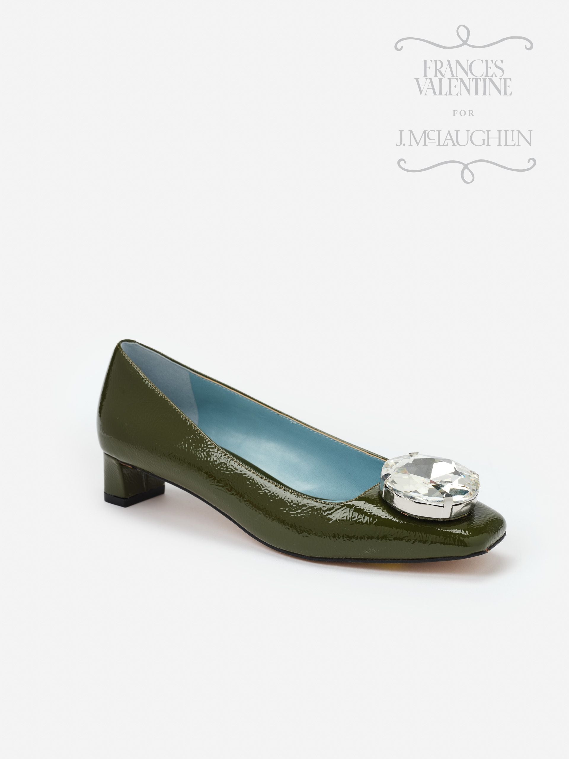 Olive green patent leather Mary Block Heels with a low block heel and large crystal embellishment on the toe, reflecting J.McLaughlin’s legacy of timeless fashion and enduring designs.
