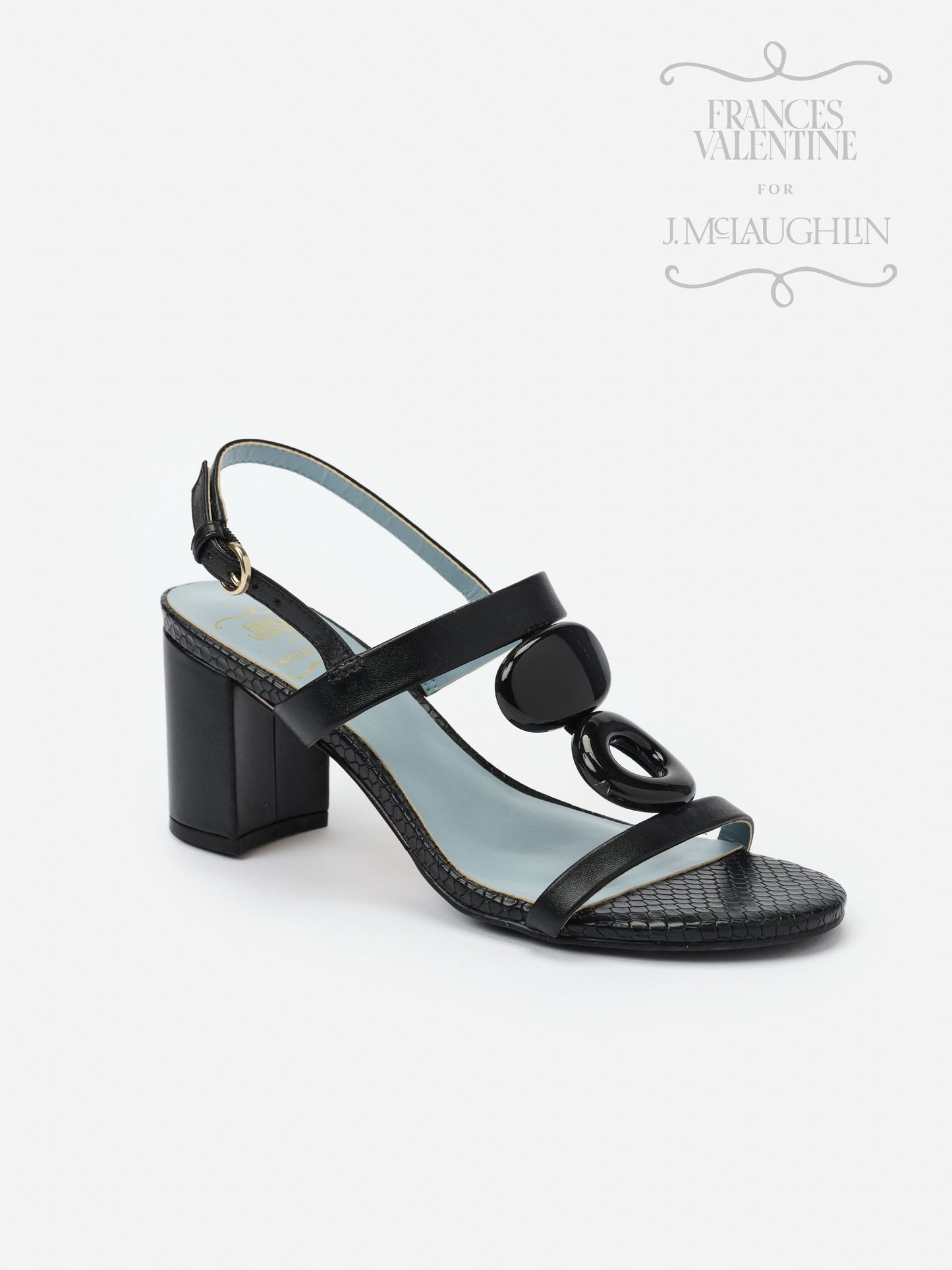 Black Bianca Heels by J.McLaughlin featuring a block heel, textured strap, and glossy decorative accents, embodying effortlessly stylish, enduring designs for a legacy of timeless fashion.