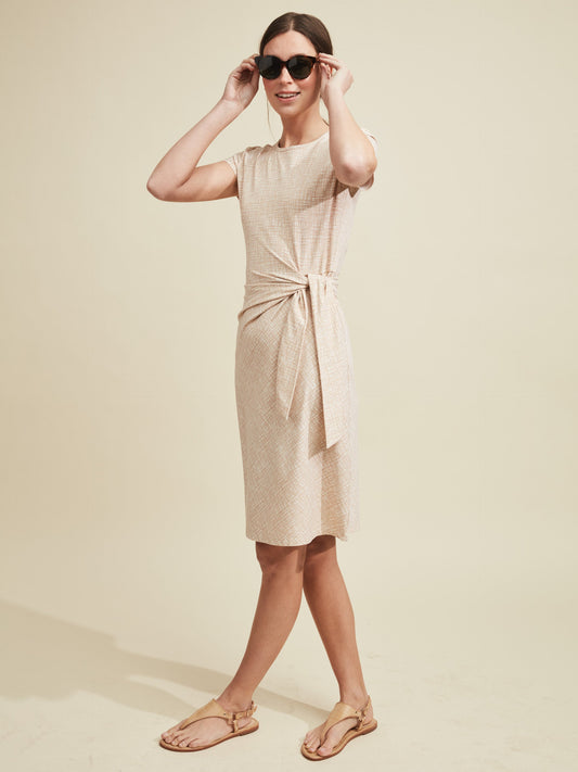 Model wearing J.McLaughlin Elora dress in off white/tan made with Catalina cloth.