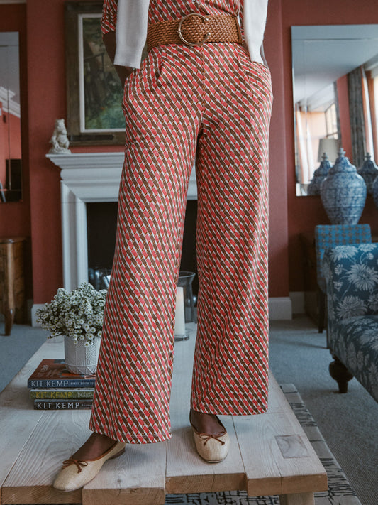 Model wears J.McLaughlin Pasha pants in coral/brown made with polyester/spandex.