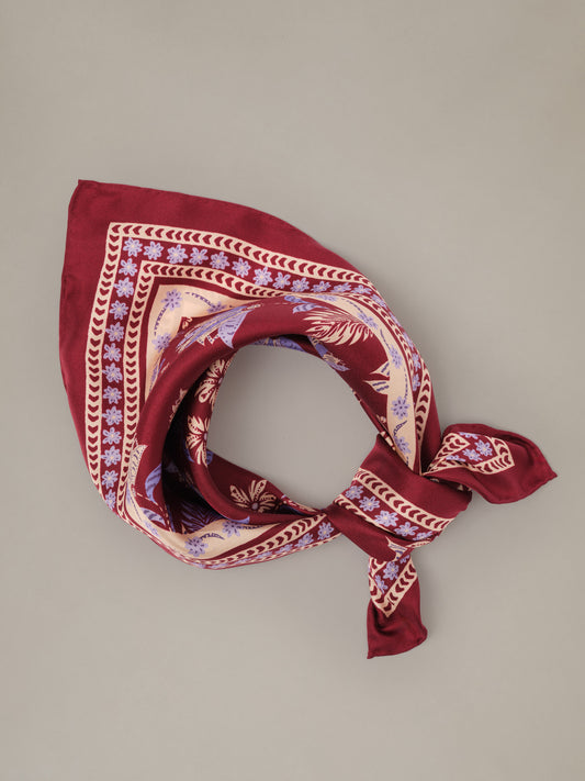 The Eloise Silk Scarf in Hastings Garden by J.McLaughlin red silk scarf with an intricate floral border pattern styled in a classic tied wrap