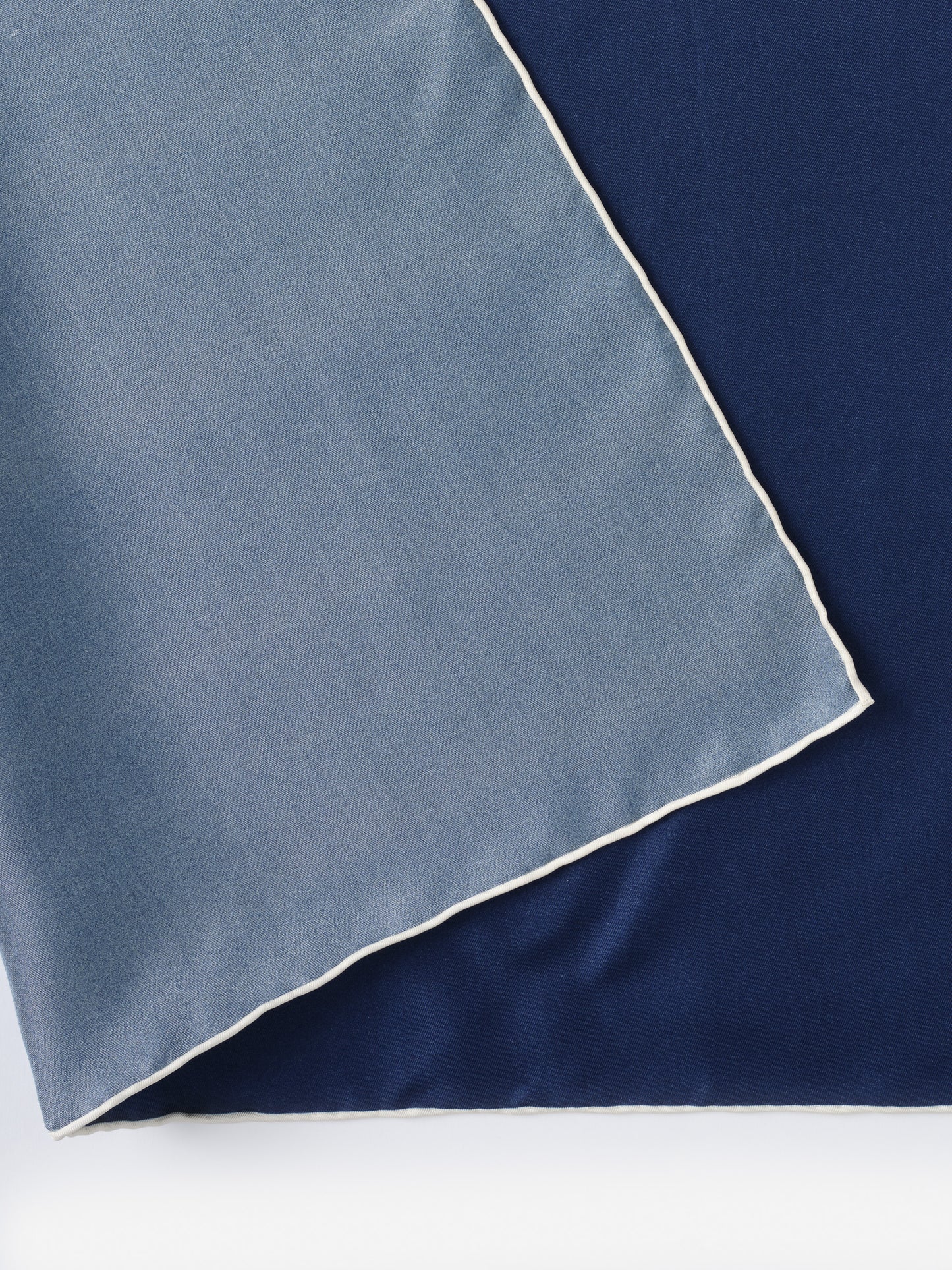 Close-up of the Kyleigh Silk Scarf by J.McLaughlin in shades of blue with a delicate white trim, showcasing effortlessly stylish, enduring designs and innovative fabrics.