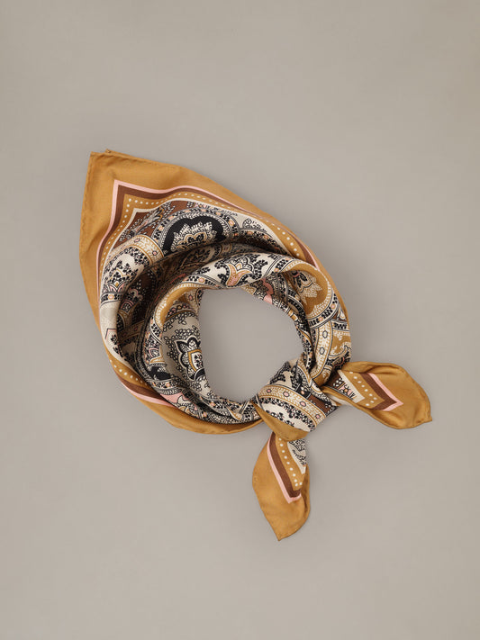 The Eloise Silk Scarf in Far Paisley by J.McLaughlin featuring an ornate paisley print in warm gold and neutral tones