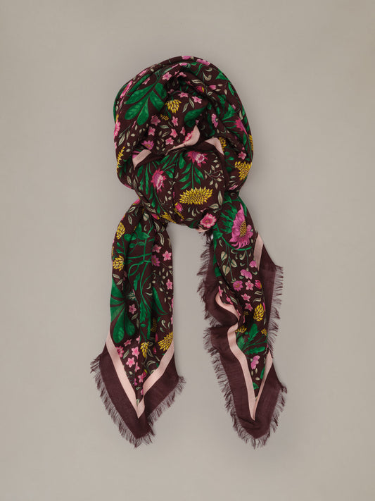 The Katherine Scarf in Mega Manor Floral Border soft modal wool scarf with a dark floral print draped in an elegant loop with fringed edges