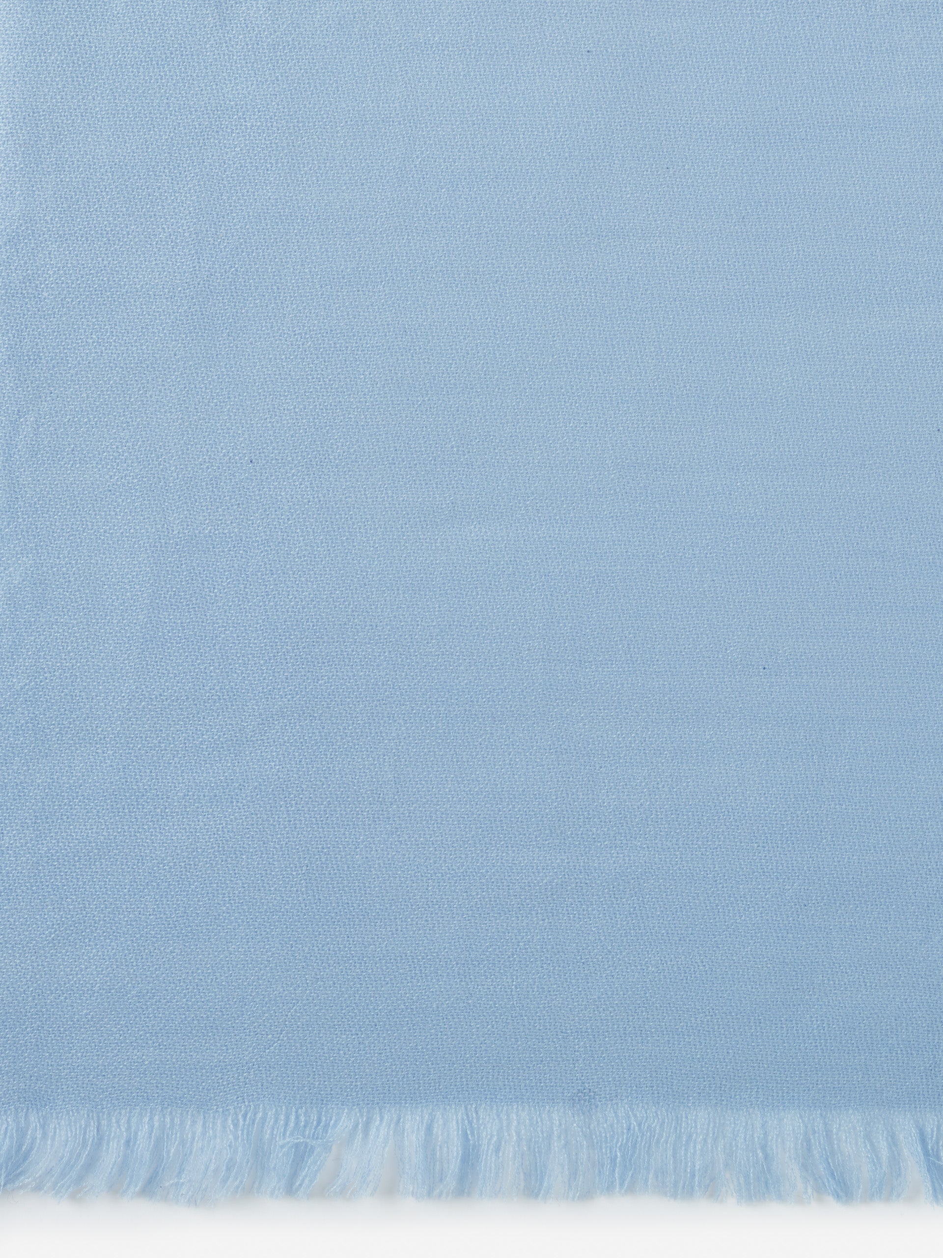 Light blue Carey Cashmere Scarf by J.McLaughlin featuring finely woven fabric and delicate fringe edges, embodying effortlessly stylish, enduring designs with a legacy of timeless fashion.