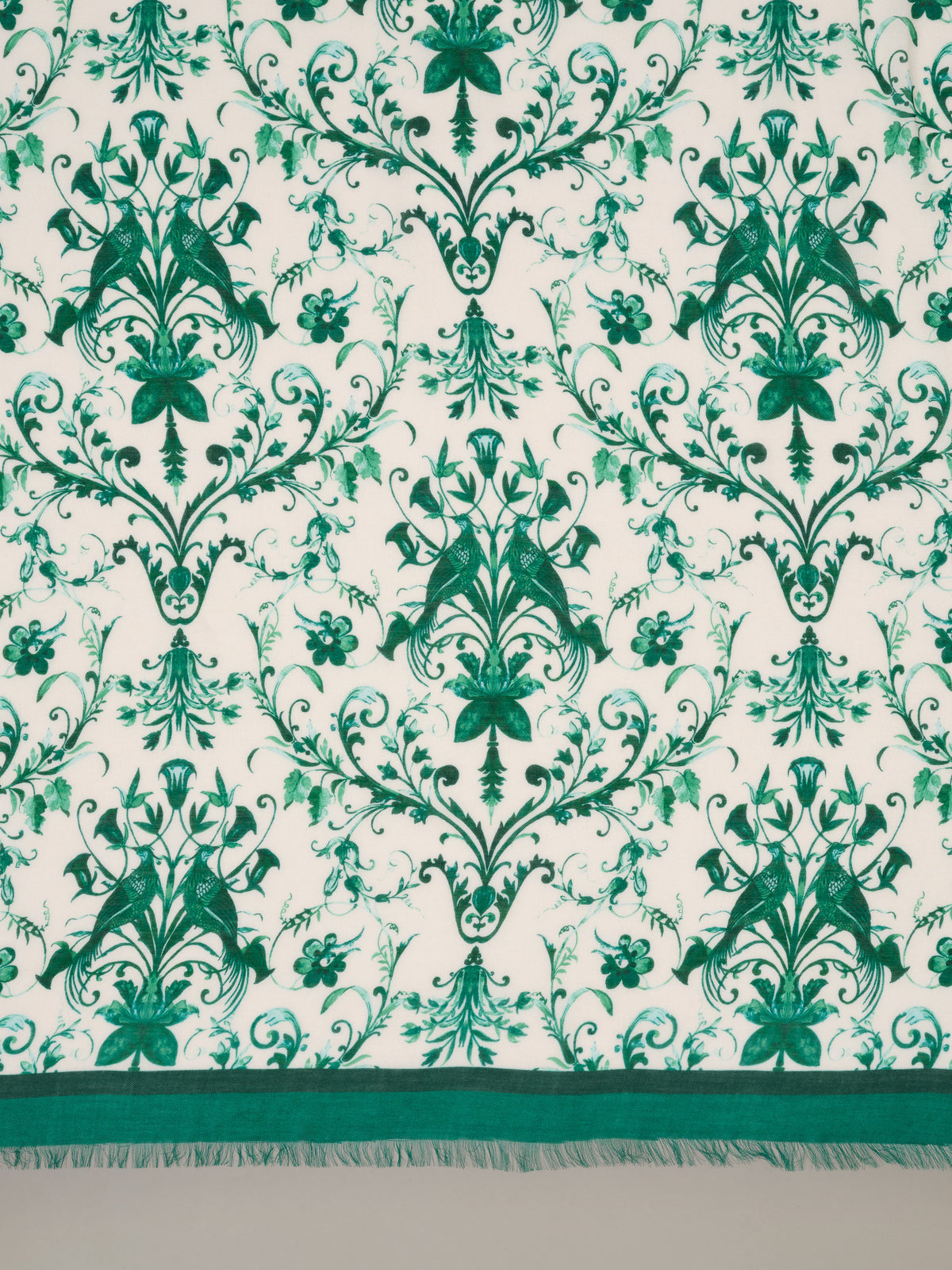 The Katherine Scarf in Garden Flight Border by J.McLaughlin shown in a green botanical pattern with a deep green border and delicate fringe