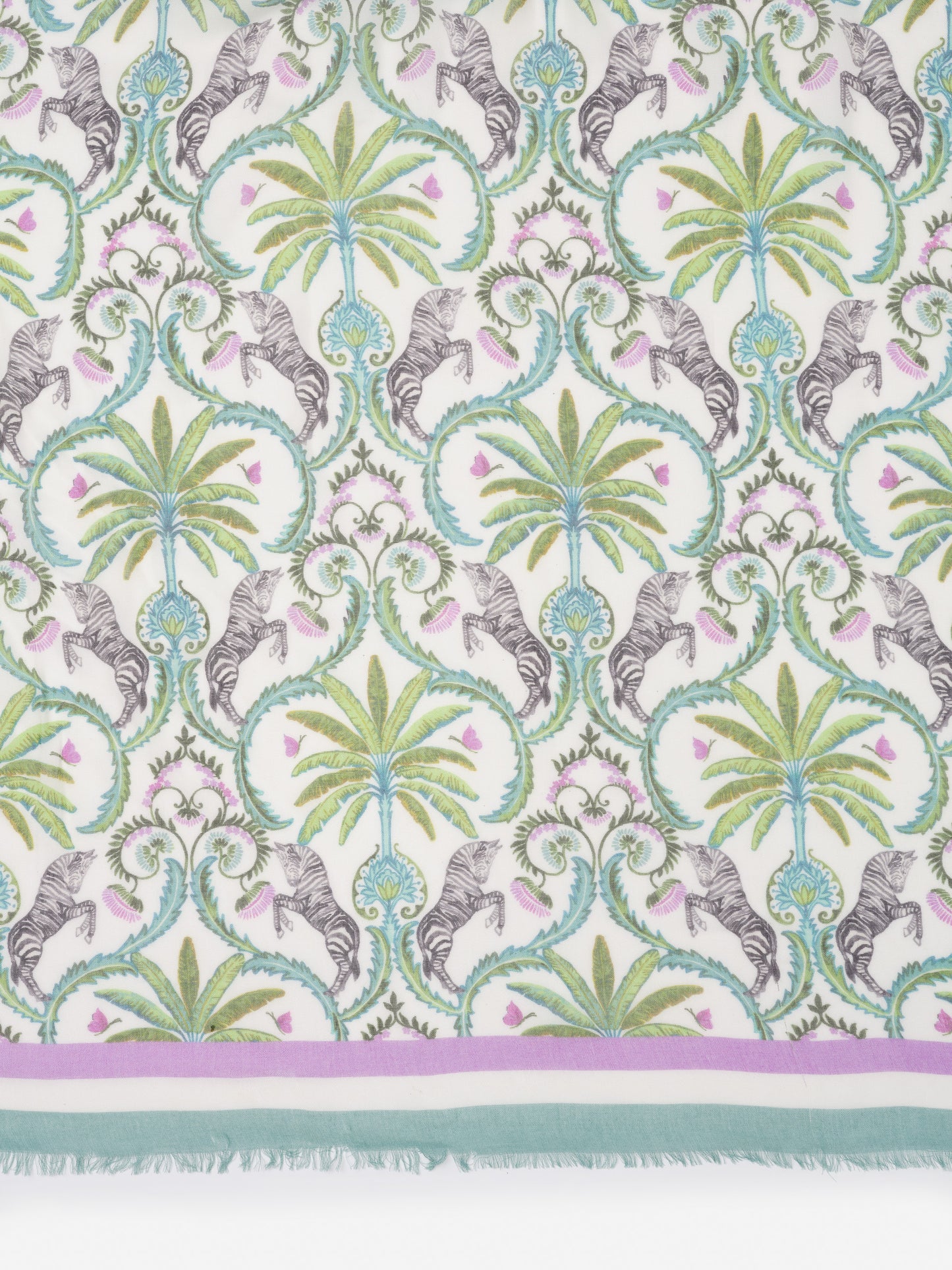 Giselle Scarf in Zebra Isle Border with green palm motifs, black and white zebras, and a delicate floral pattern by J.McLaughlin, showcasing effortlessly stylish scarves and enduring designs.