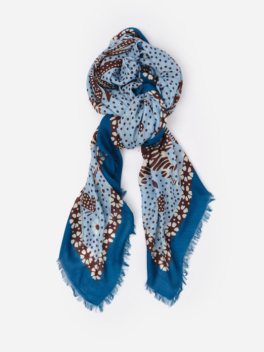 The Katherine Scarf in Folk Tale Border by J.McLaughlin features an effortlessly stylish blue and brown patterned design with soft fabric and delicate fringed edges.