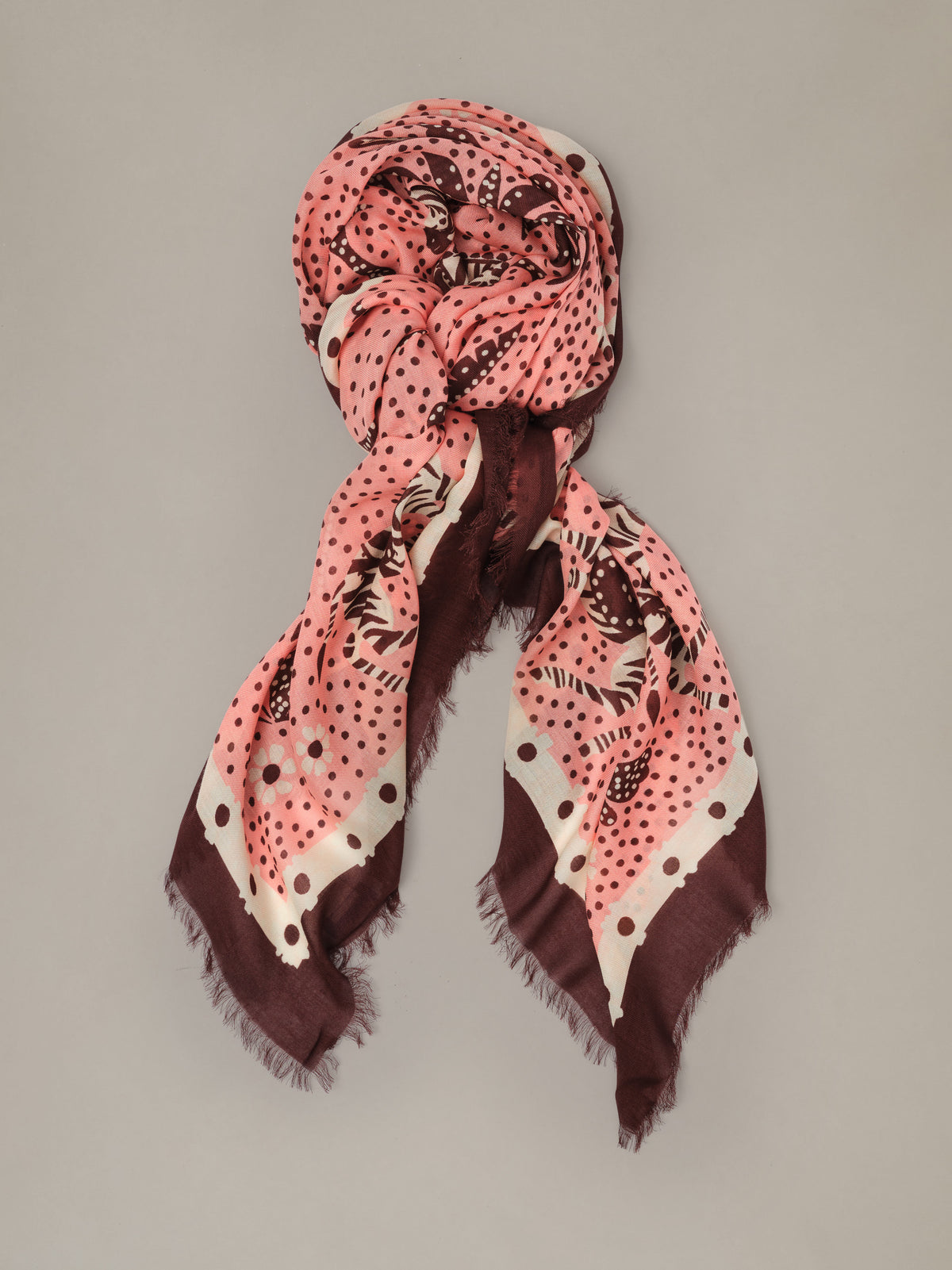The Katherine Scarf in Folk Tale Border by J.McLaughlin is a pink and burgundy patterned scarf styled in a soft draped wrap with fringed edges