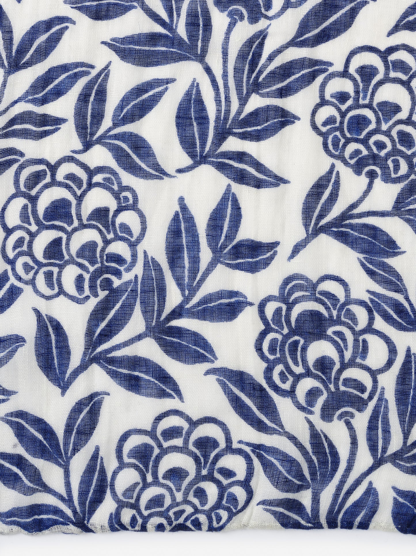 Close-up of a white linen fabric with an indigo floral pattern, part of the Men's Linen Scarf in Modern Dahlia by J.McLaughlin, showcasing effortlessly stylish, enduring designs and innovative fabrics.