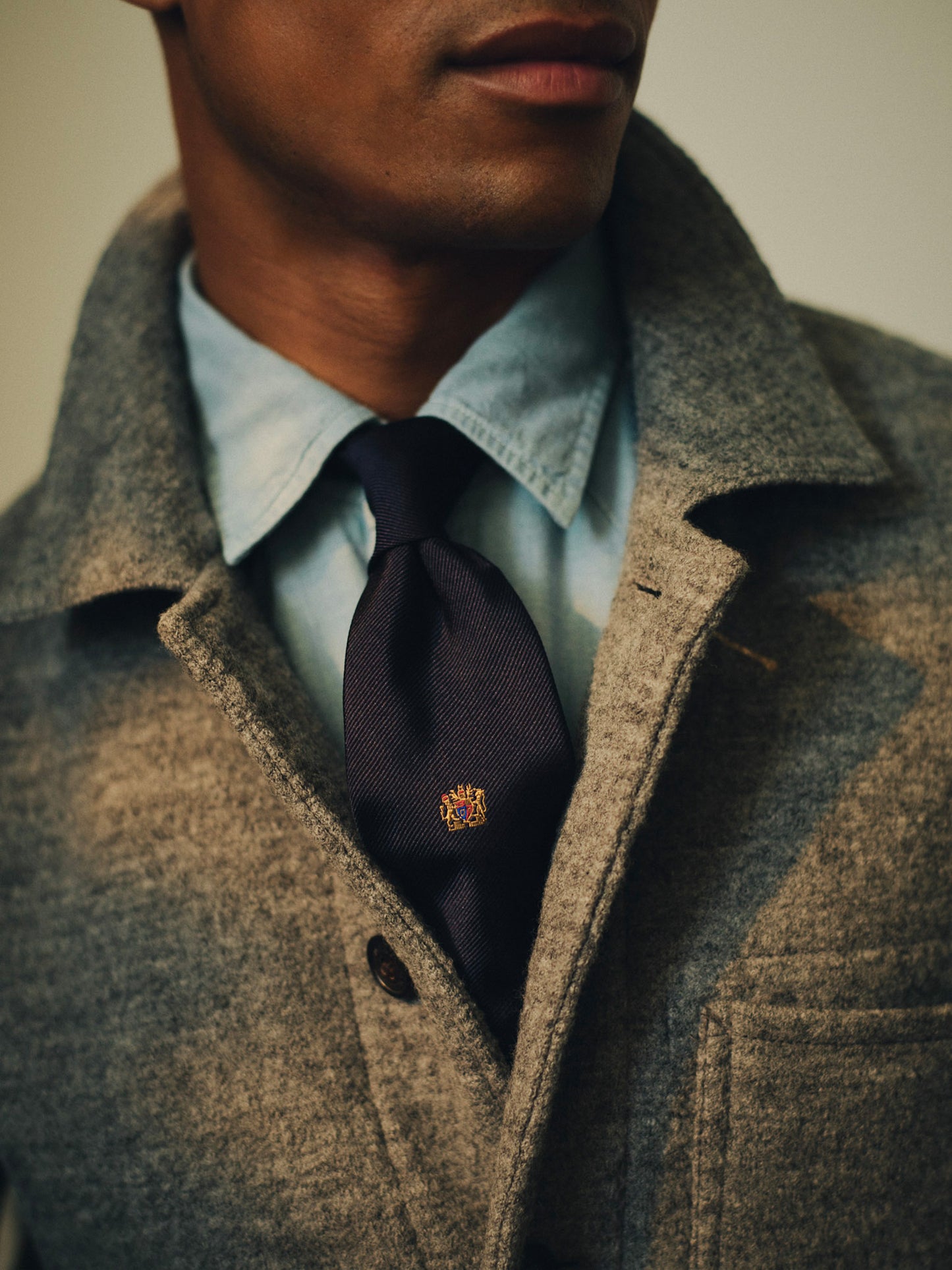 Silk Tie in Crested Lion by J.McLaughlin worn with a light blue shirt and textured coat featuring a refined lion crest for timeless style