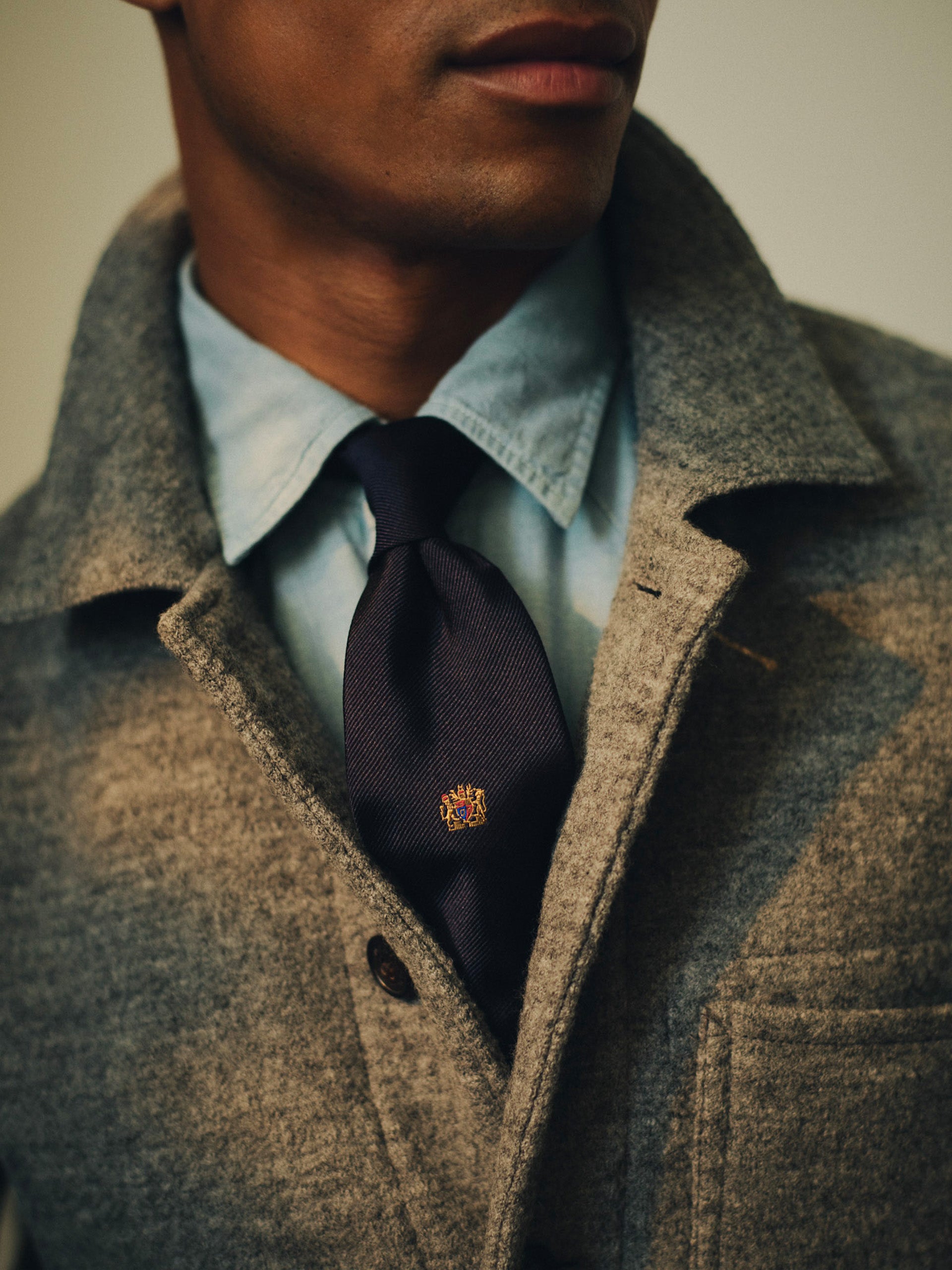 Silk Tie in Crested Lion by J.McLaughlin worn with a light blue shirt and textured coat featuring a refined lion crest for timeless style