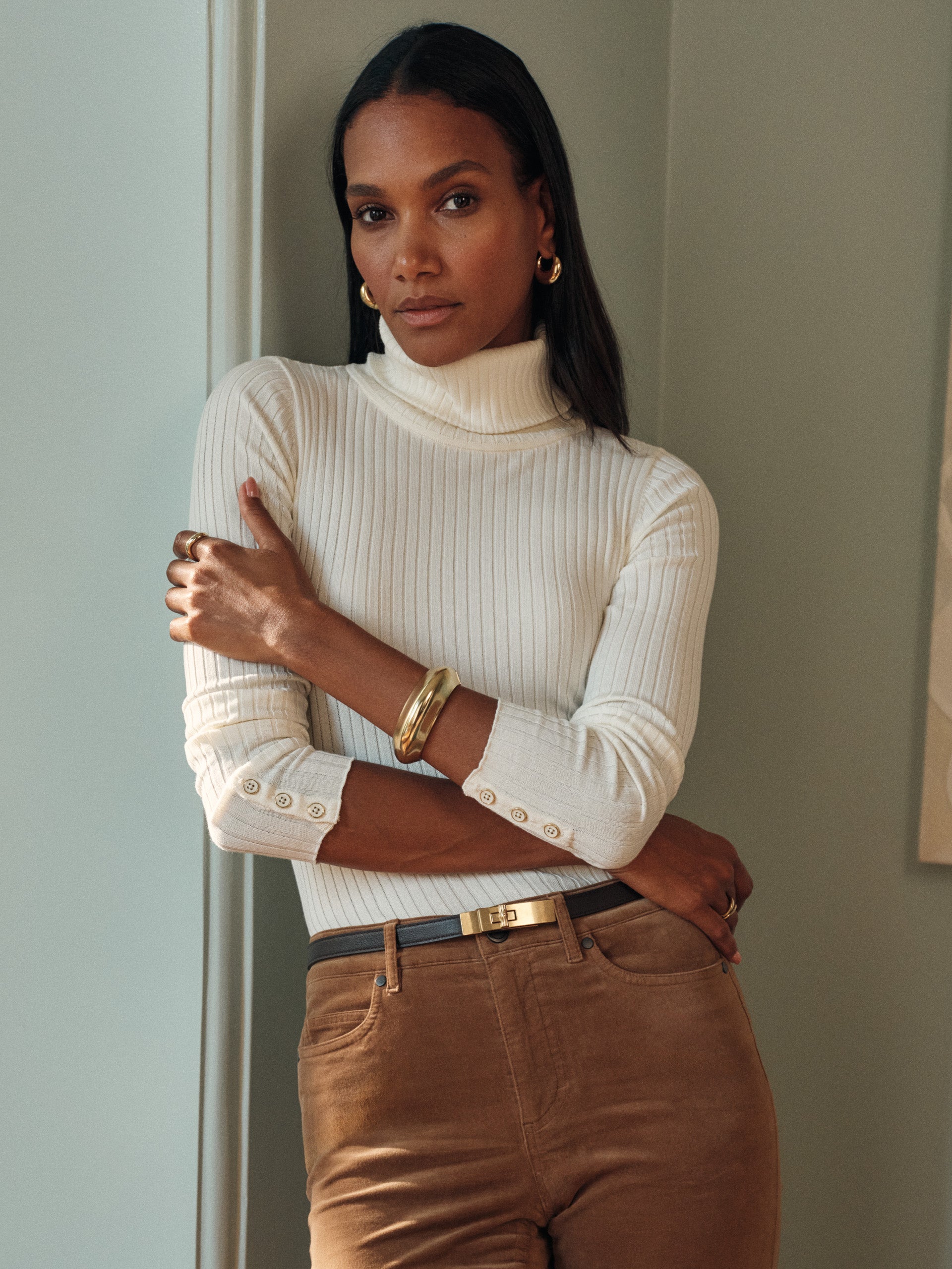 Model wearing J.McLaughlin Arlette turtleneck in egret white made with cotton/modal.