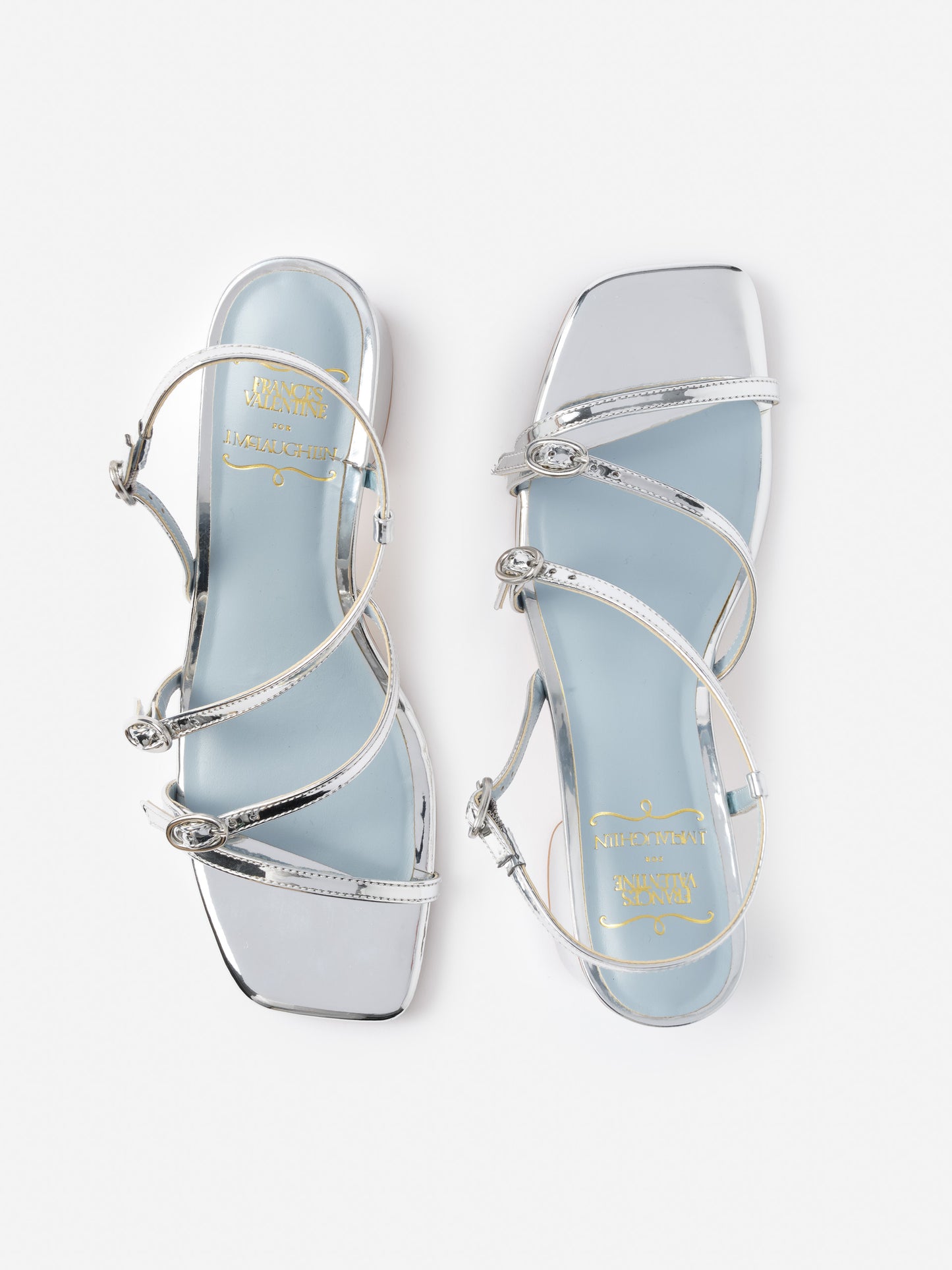 Pair of silver Lexi Heels by J.McLaughlin featuring delicate straps and a square toe, showcasing effortlessly stylish, enduring designs with innovative fabrics for a legacy of timeless fashion.