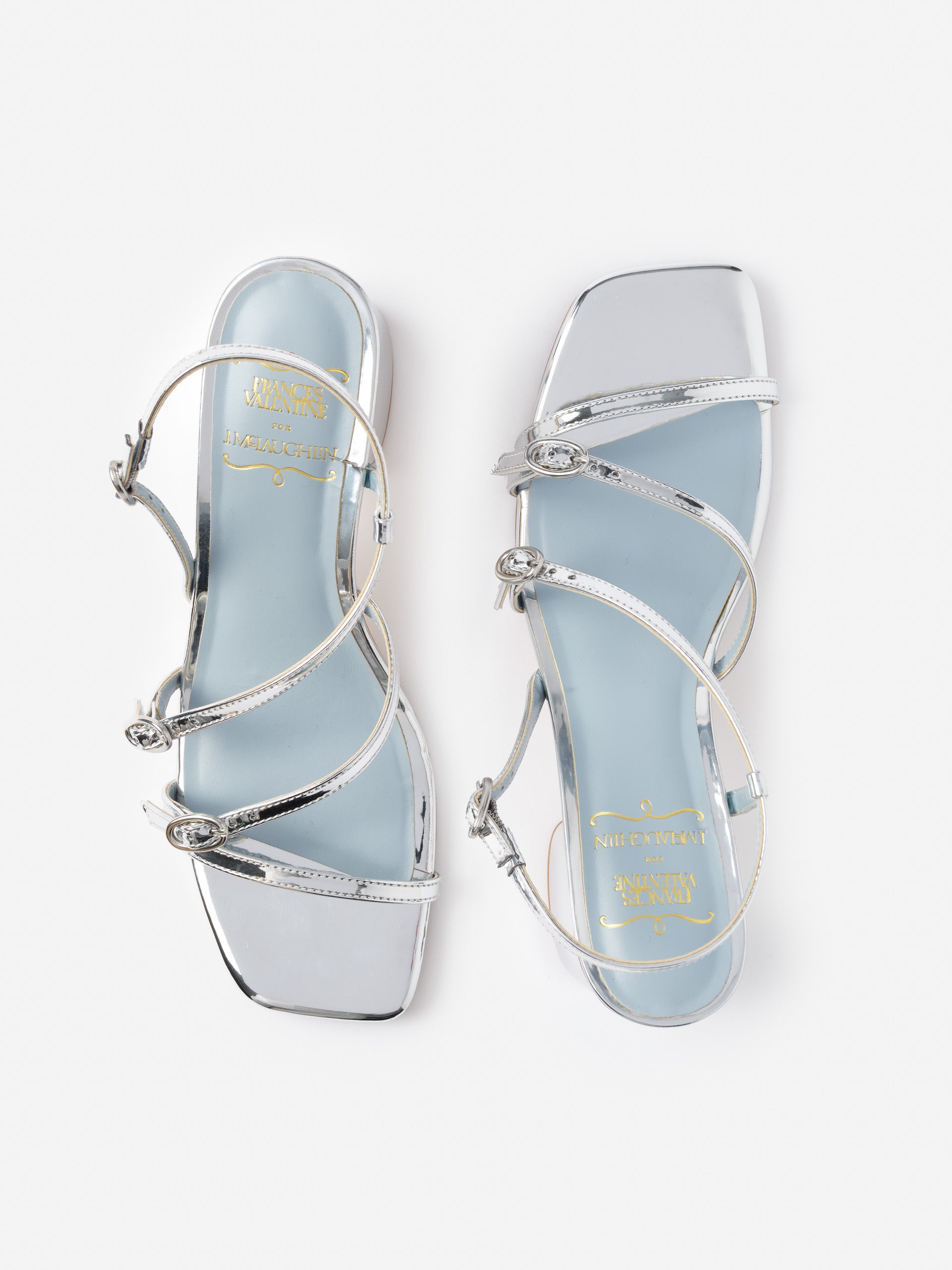 Pair of silver Lexi Heels by J.McLaughlin featuring delicate straps and a square toe, showcasing effortlessly stylish, enduring designs with innovative fabrics for a legacy of timeless fashion.