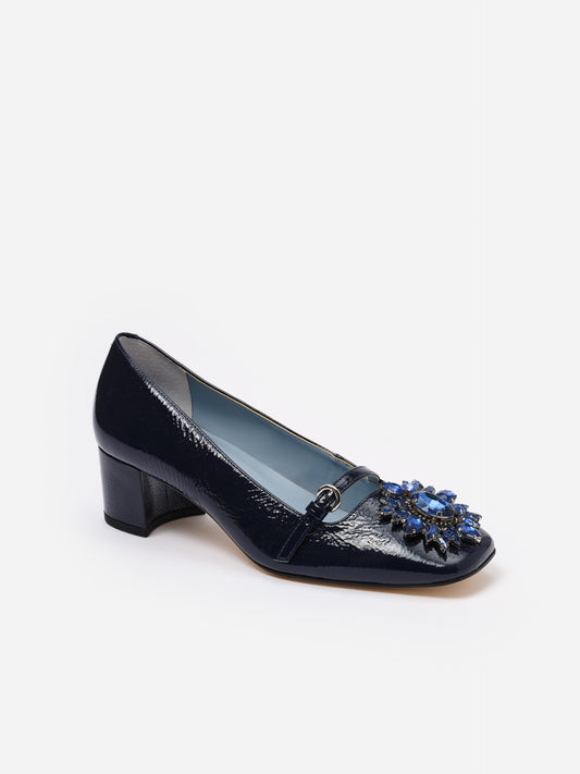 Jojo Leather Mary Jane Pumps by J.McLaughlin in glossy navy leather featuring a low block heel and a floral rosette buckle embellished with blue stones for a timeless, stylish look.