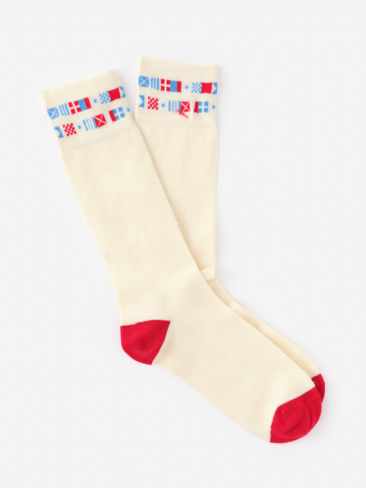 Socks in Nautical Flag by J.McLaughlin featuring an effortlessly stylish cream base with red accents and a band of colorful nautical flags, showcasing enduring designs in innovative fabrics.