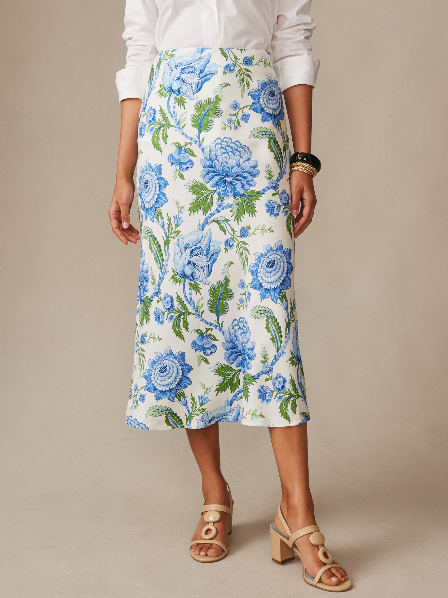 Woman wearing an effortlessly stylish Adelyn Silk Blend Skirt in Cerulean Garden Bias by J.McLaughlin, featuring blue and green floral patterns on ivory, embodying enduring designs and a legacy of timeless fashion. A destination for defining style. Life, Well-Lived.