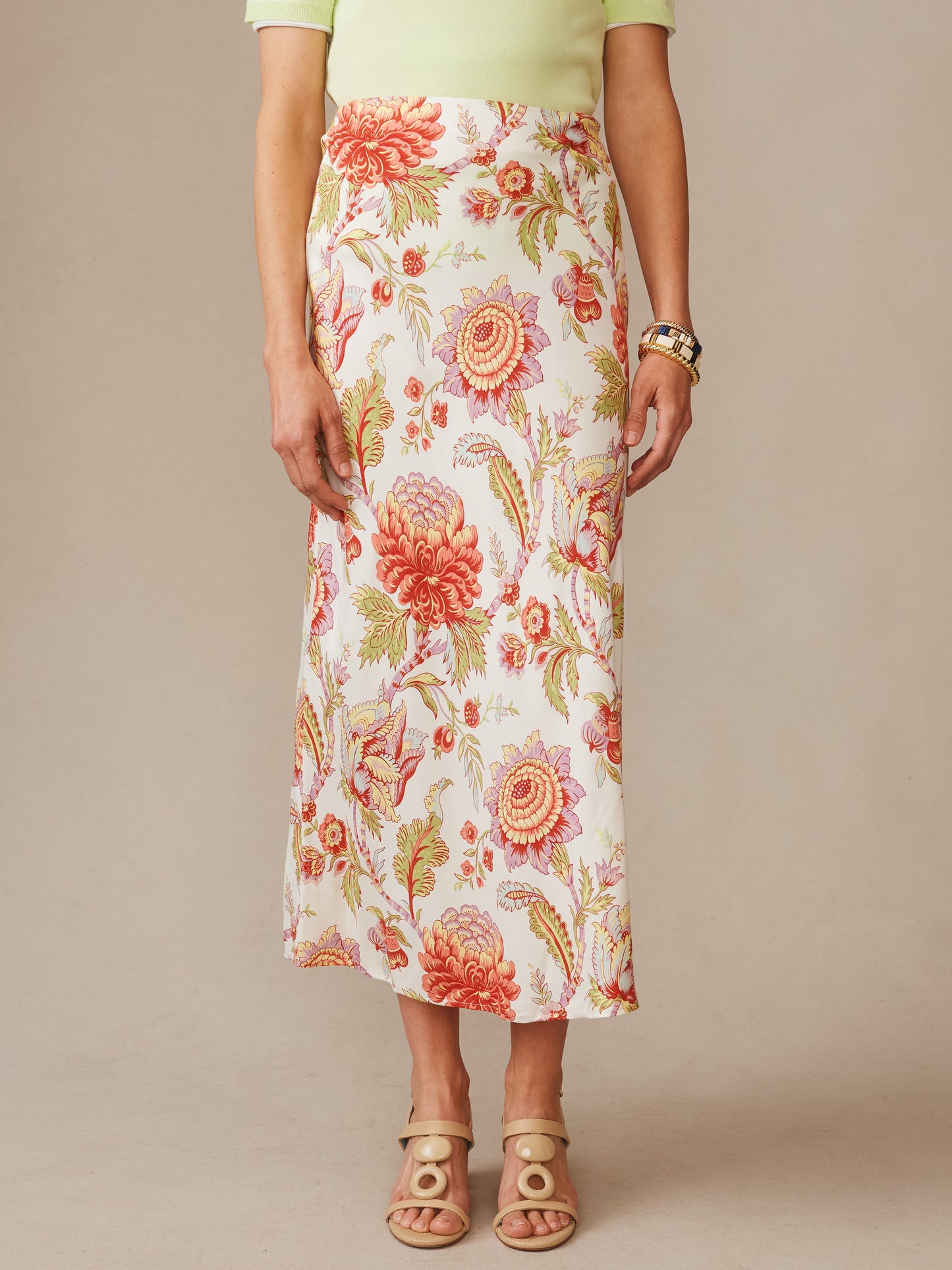 Model wearing the Adelyn Silk Blend Skirt in Cerulean Garden Bias by J.McLaughlin, featuring a floral pattern in warm tones, styled with neutral sandals and a light top, embodying effortlessly stylish, enduring designs with innovative fabrics, a legacy of timeless fashion. A destination for defining style. Life, Well-Lived.