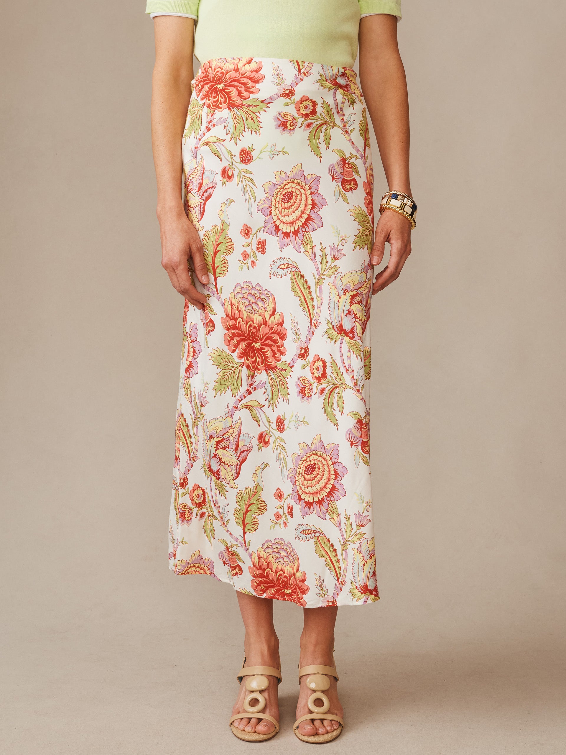 Model wearing the Adelyn Silk Blend Skirt in Cerulean Garden Bias by J.McLaughlin, featuring a floral pattern in warm tones, styled with neutral sandals and a light top, embodying effortlessly stylish, enduring designs with innovative fabrics, a legacy of timeless fashion. A destination for defining style. Life, Well-Lived.